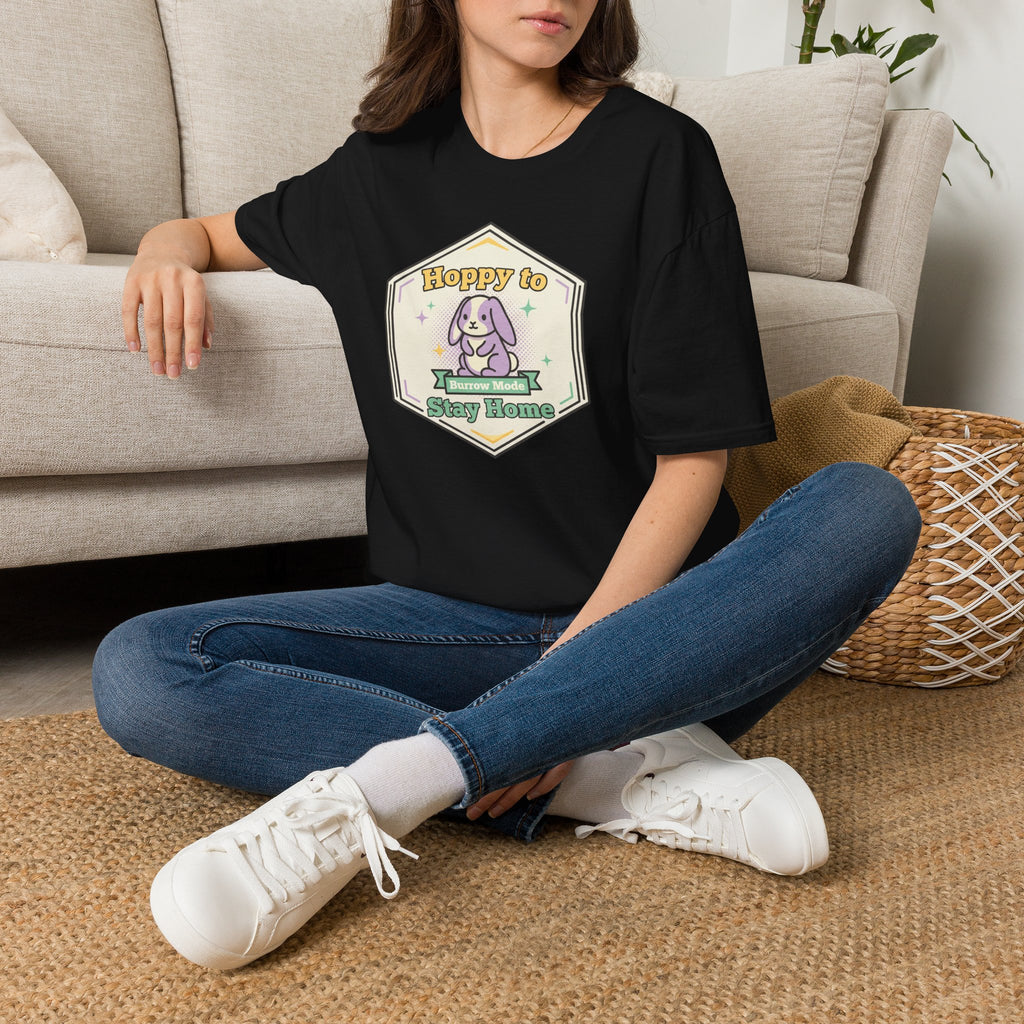 Black unisex graphic T-shirt with centered bunny 'Stay Home' badge, worn by model