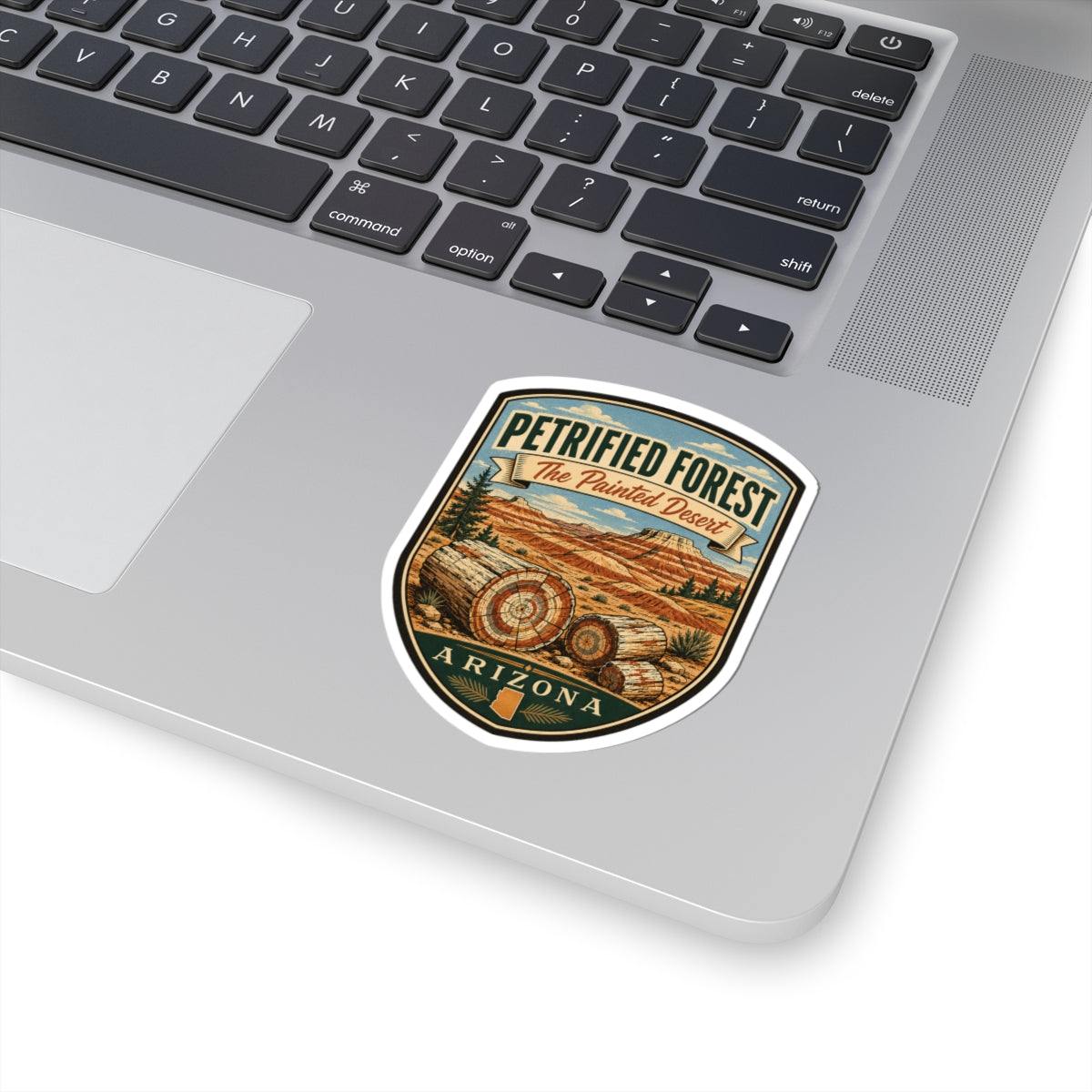 Petrified Forest travel sticker on a laptop, shield badge with desert logs and Arizona