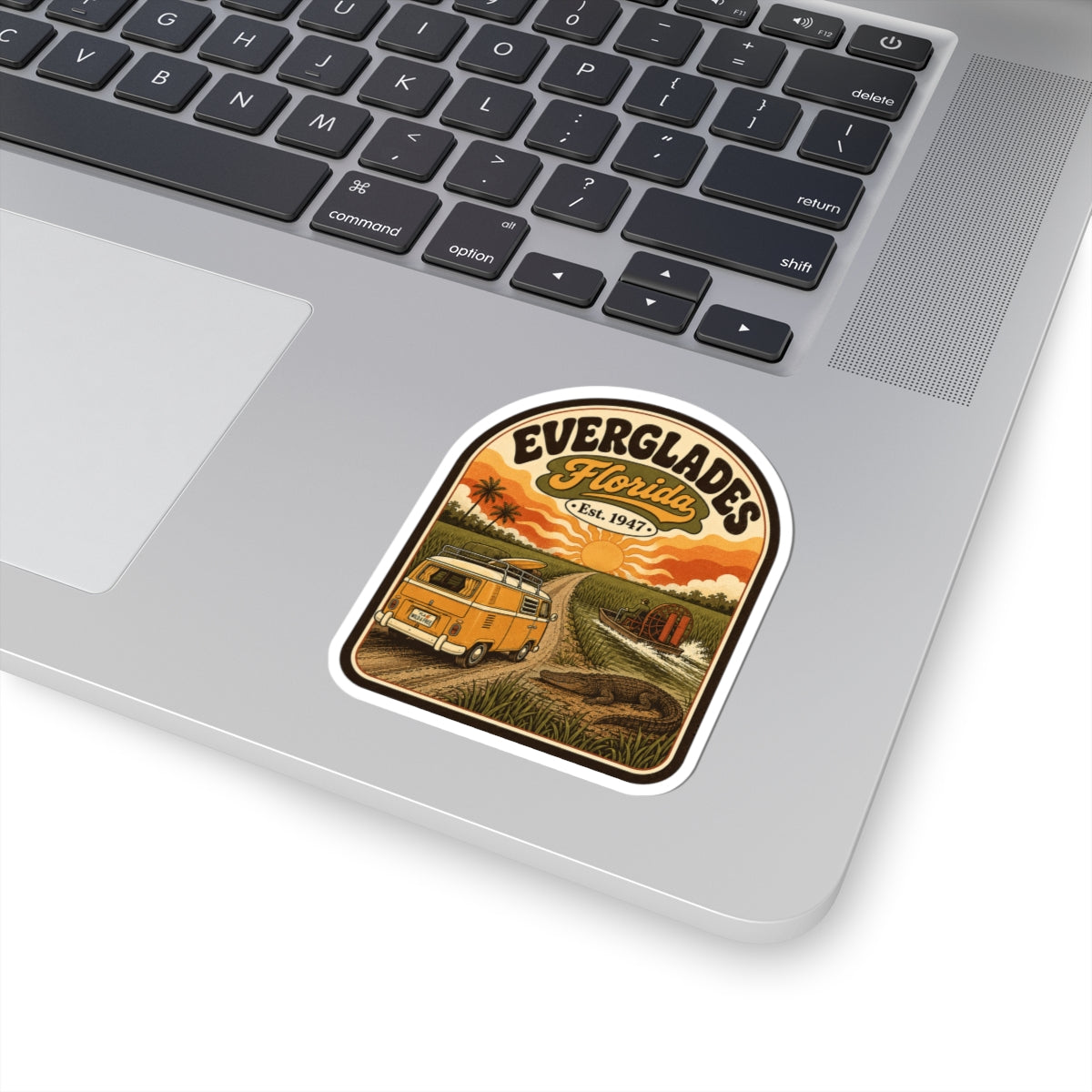 Everglades Florida vintage camper sticker on silver laptop keyboard, orange van sunset graphic