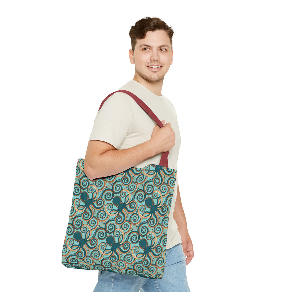 Octopus swirl tote bag worn on shoulder; teal all-over pattern with burgundy handles.