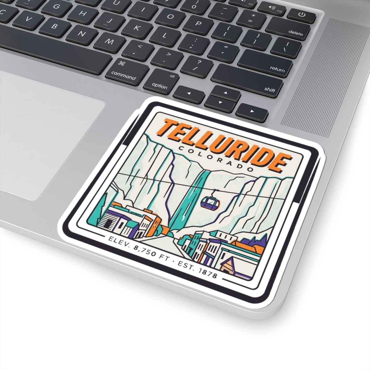 Square Telluride Colorado sticker on a laptop keyboard, showing gondola, valley lines, and buildings