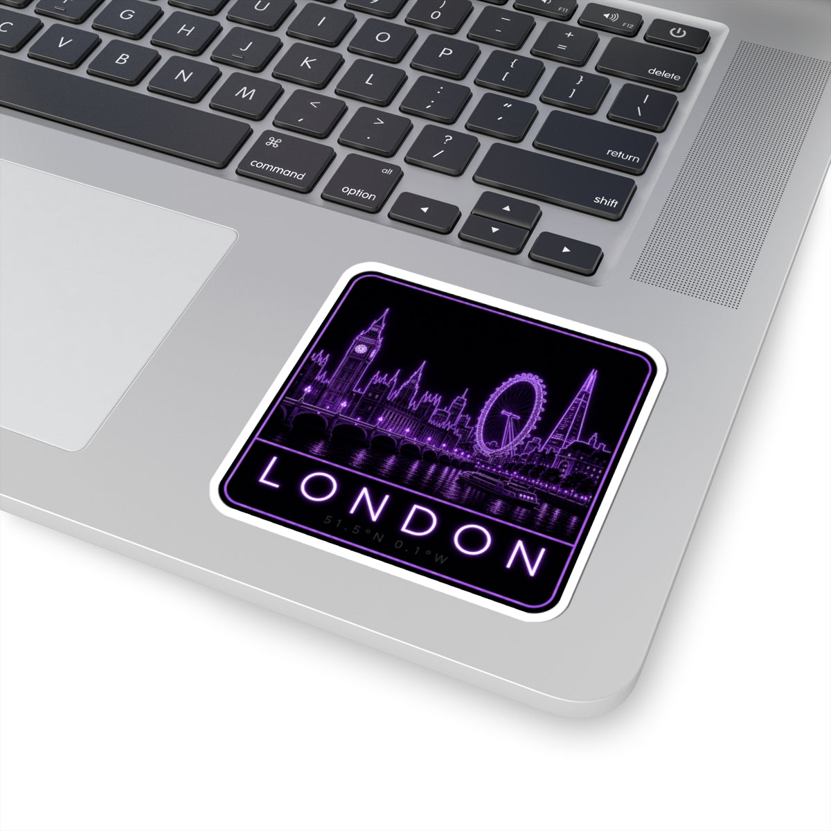 Purple neon London skyline sticker on a laptop keyboard, Ferris wheel and London text visible