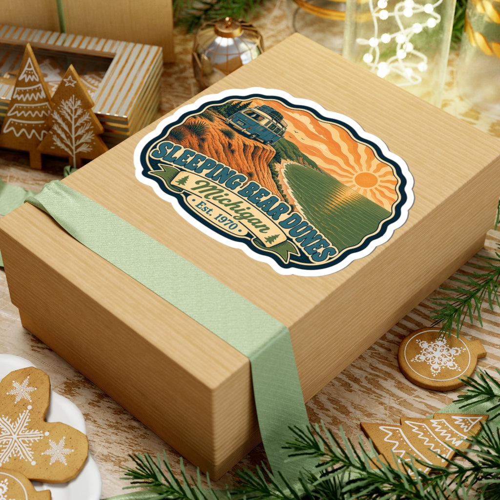 Die-cut sticker illustration with camper van, dunes, lake, sunrise, and “Sleeping Bear Dunes” lettering