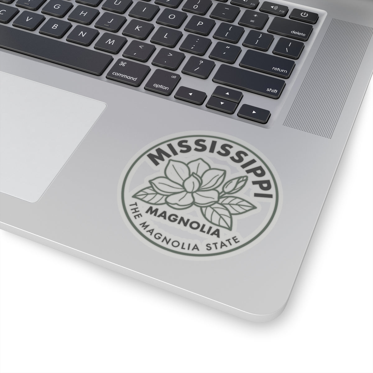 Transparent vinyl sticker on a laptop screen corner with Mississippi magnolia state seal