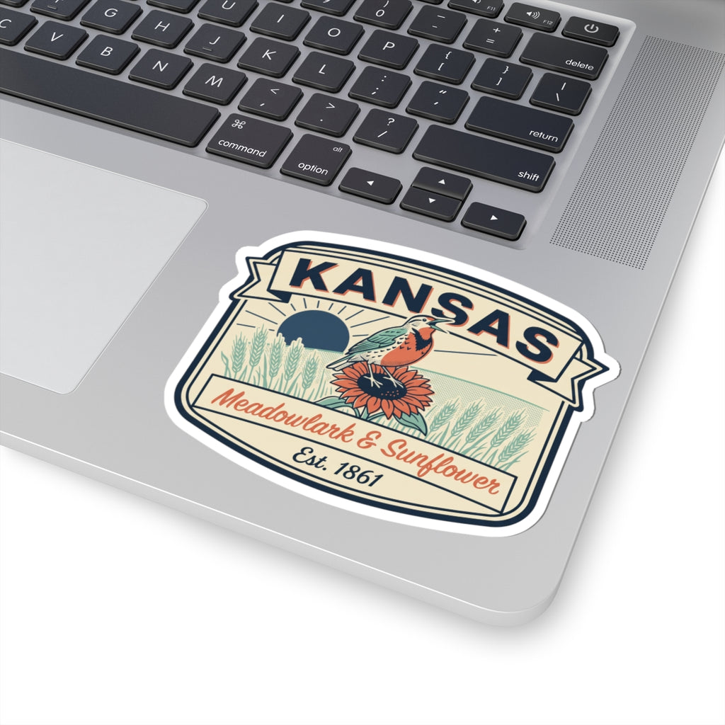 Kansas state badge sticker with meadowlark and sunflower, Est. 1861, on computer surface