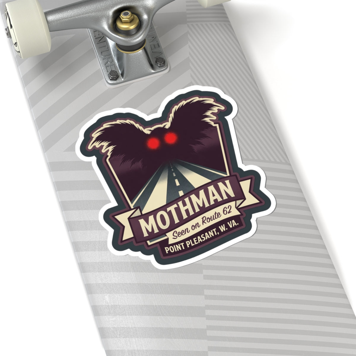 Kiss-cut Mothman sticker on a gray striped surface, with red eyes and Route 62 sign