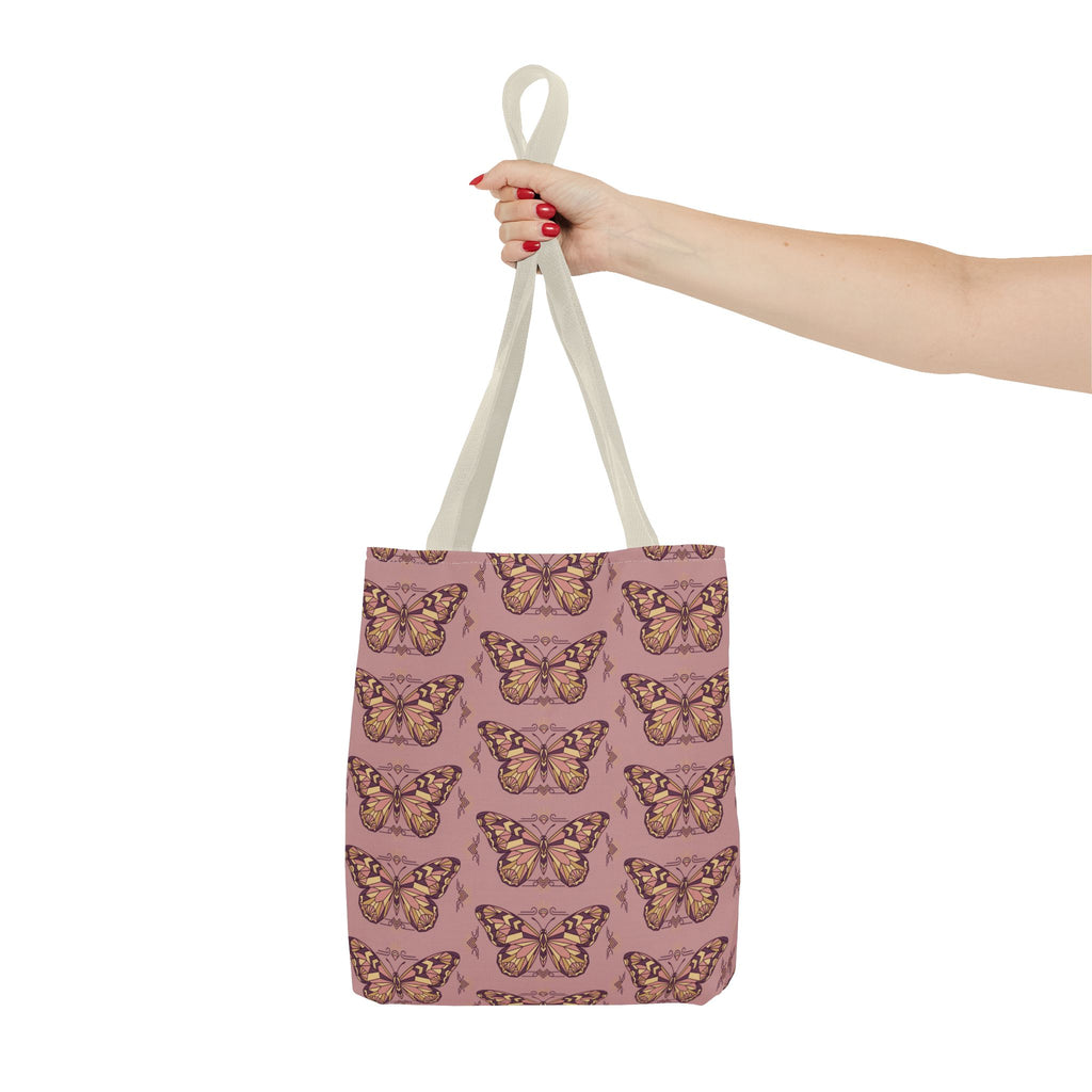 Pink butterfly print tote bag with light handles, held up by the top strap.