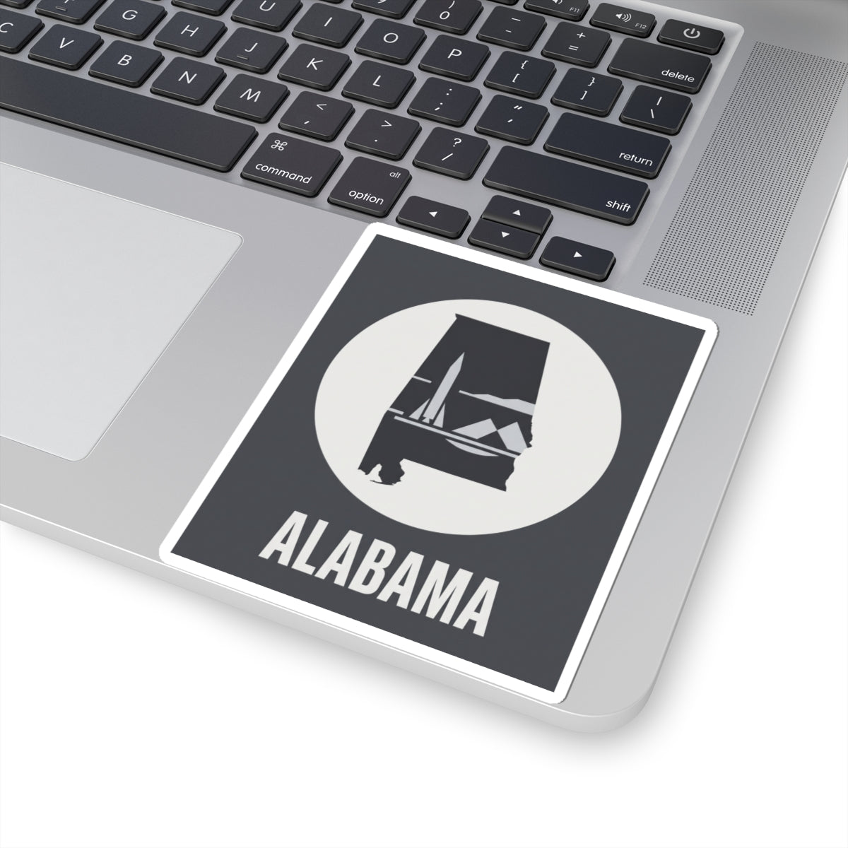 Alabama outline vinyl decal on laptop lid, square sticker with white circle emblem and “ALABAMA”
