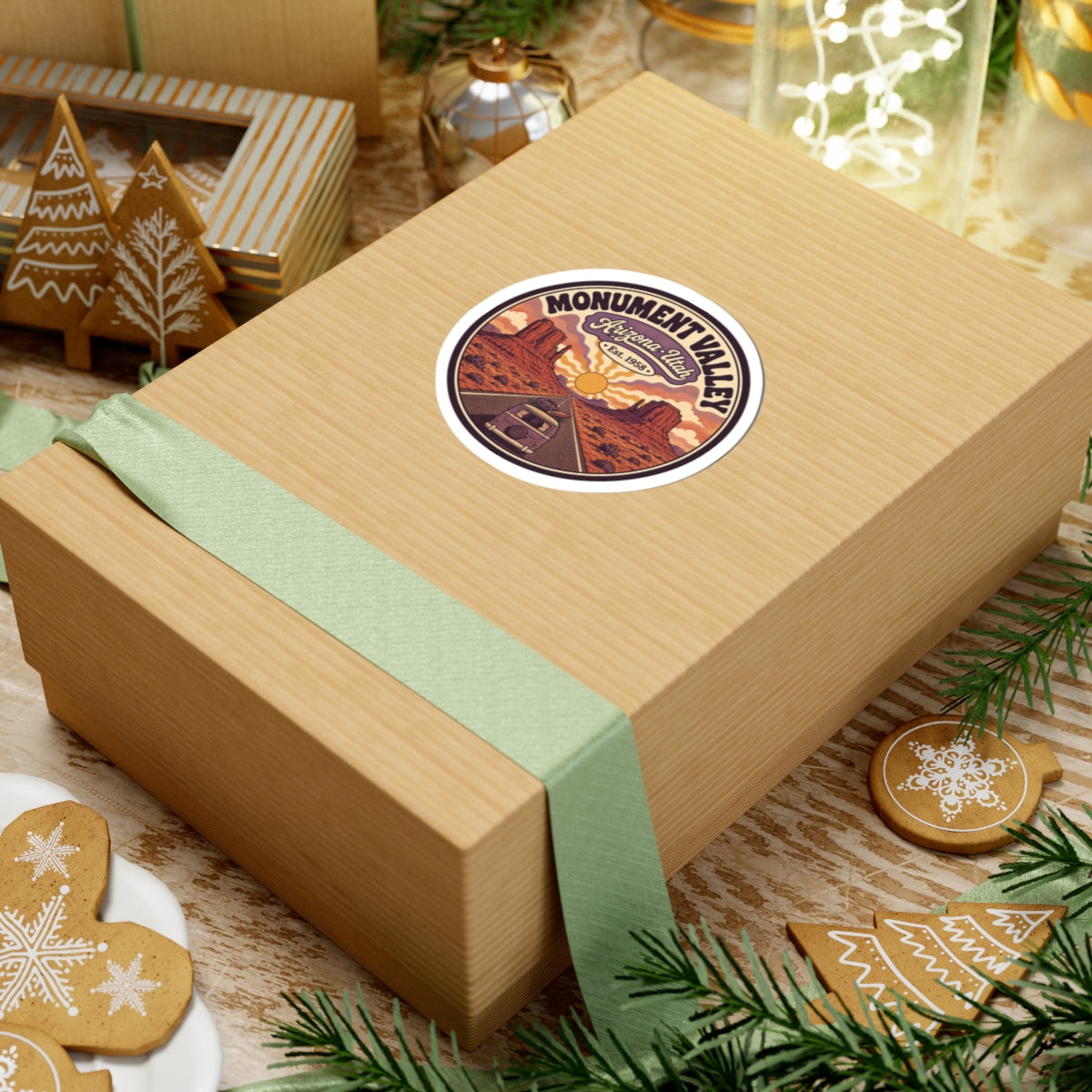 Round Monument Valley sticker on a gift box lid, showing desert mesas, sun, and van road