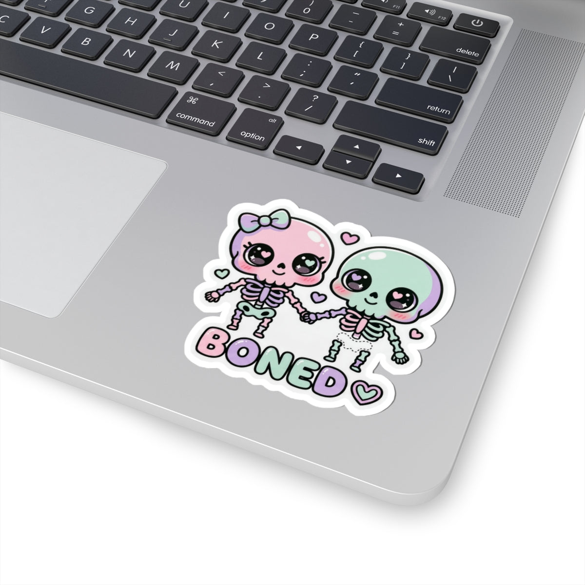 Pastel skeleton couple sticker with 'BONED' lettering and small heart accents