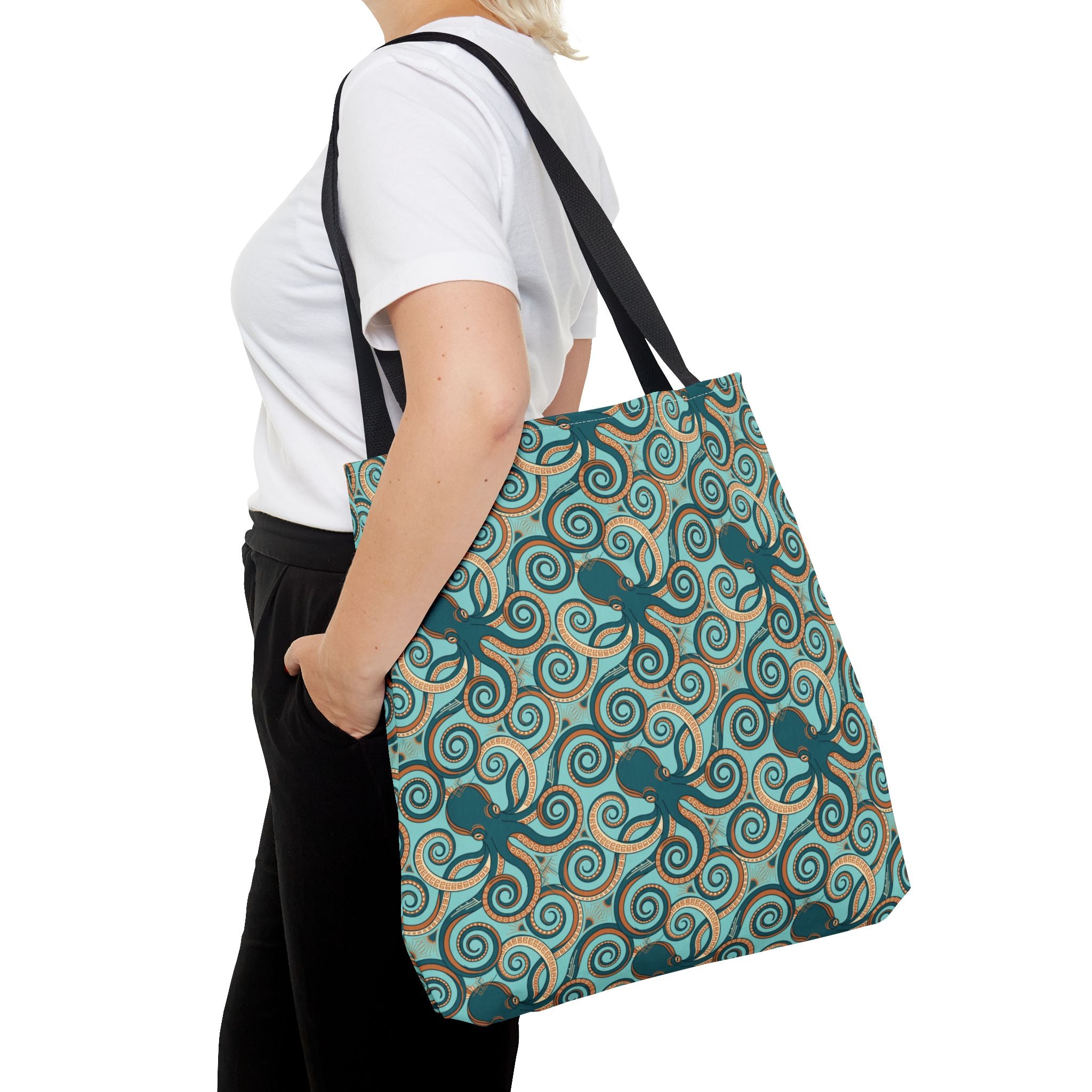 Teal octopus swirl tote bag with black strap, angled view
