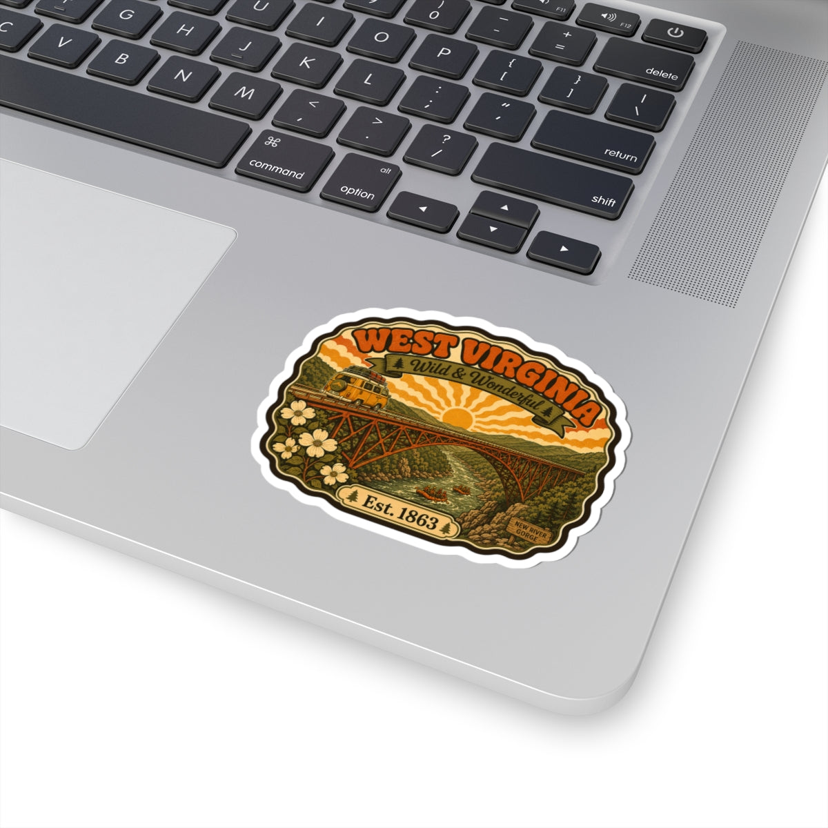 West Virginia kiss-cut sticker on a laptop, featuring bridge landscape and Est. 1863 text.