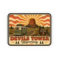 Kiss-cut sticker with orange retro landscape, green camper van, and Devil’s Tower title