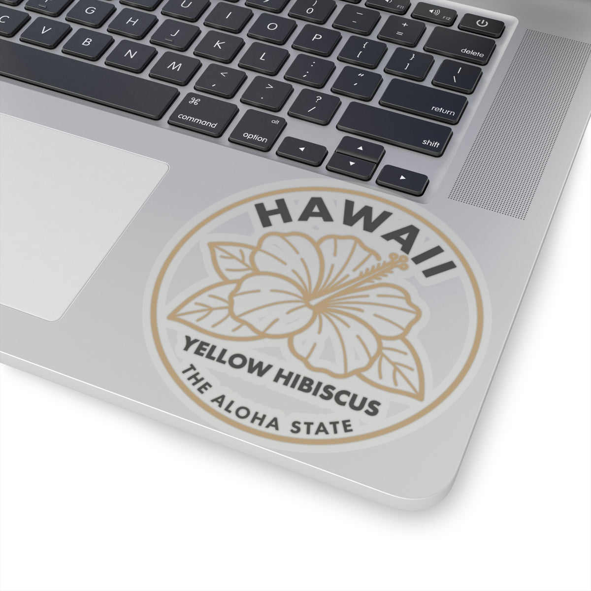Round hibiscus state sticker on laptop lid with 'HAWAII' and 'THE ALOHA STATE' text