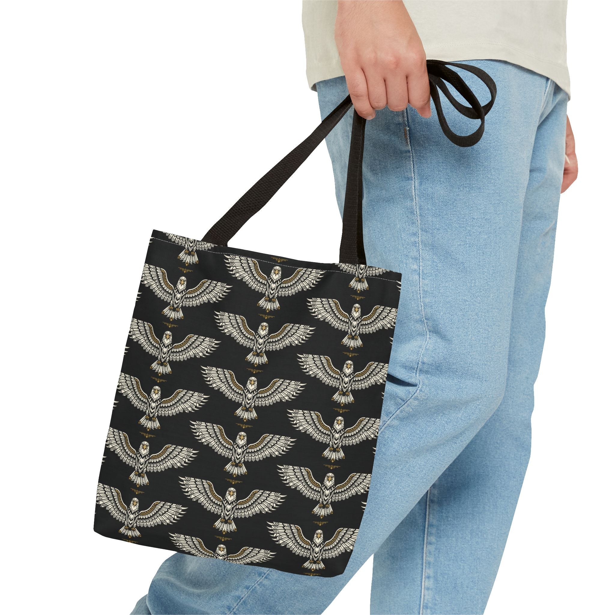 Winged scarab tote bag in black with gold emblems, held by straps, long handles