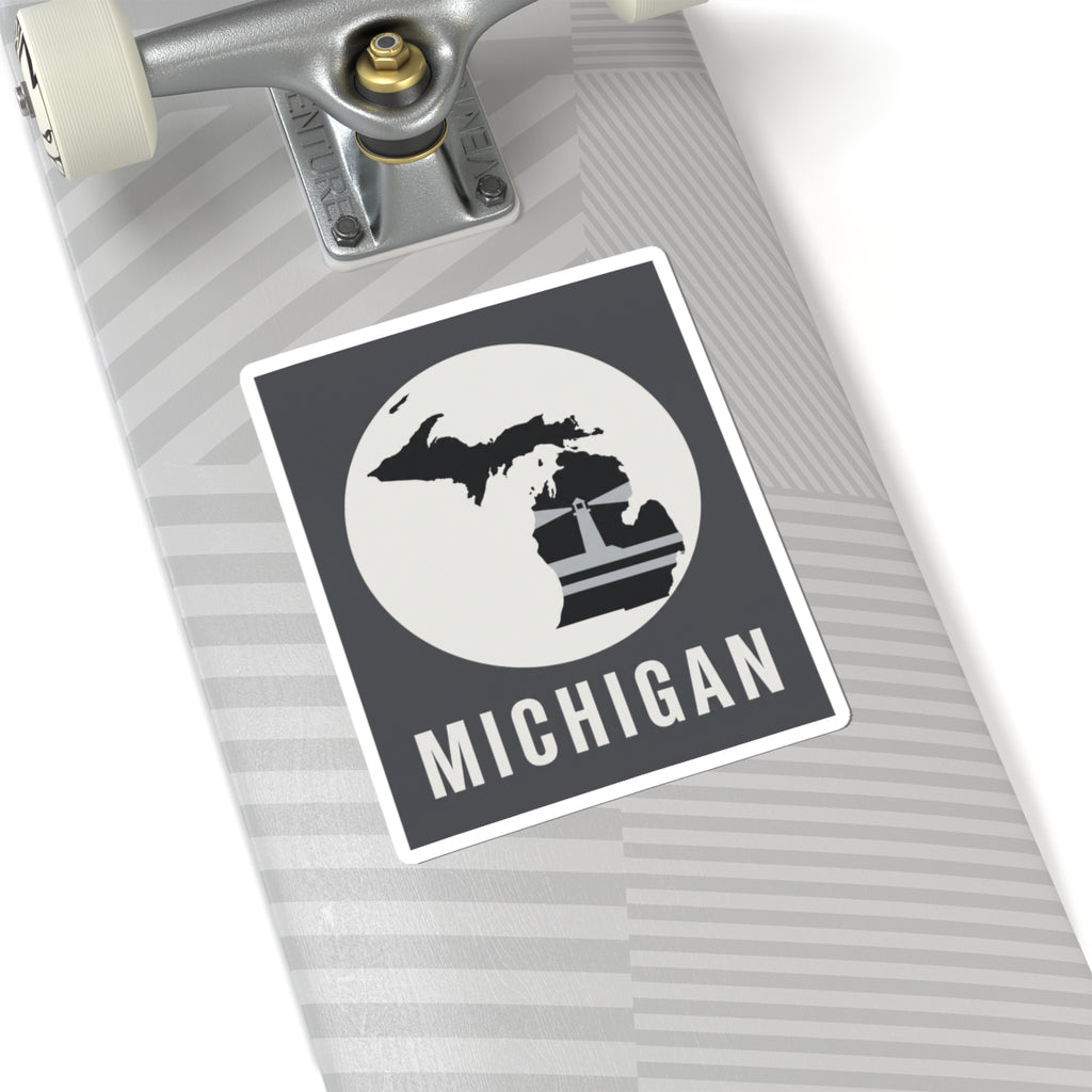 Michigan silhouette decal on notebook cover, black square with white circle and “MICHIGAN”.