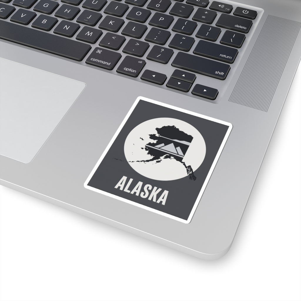 Alaska “ALASKA” text vinyl sticker on laptop surface, square dark gray and white design.