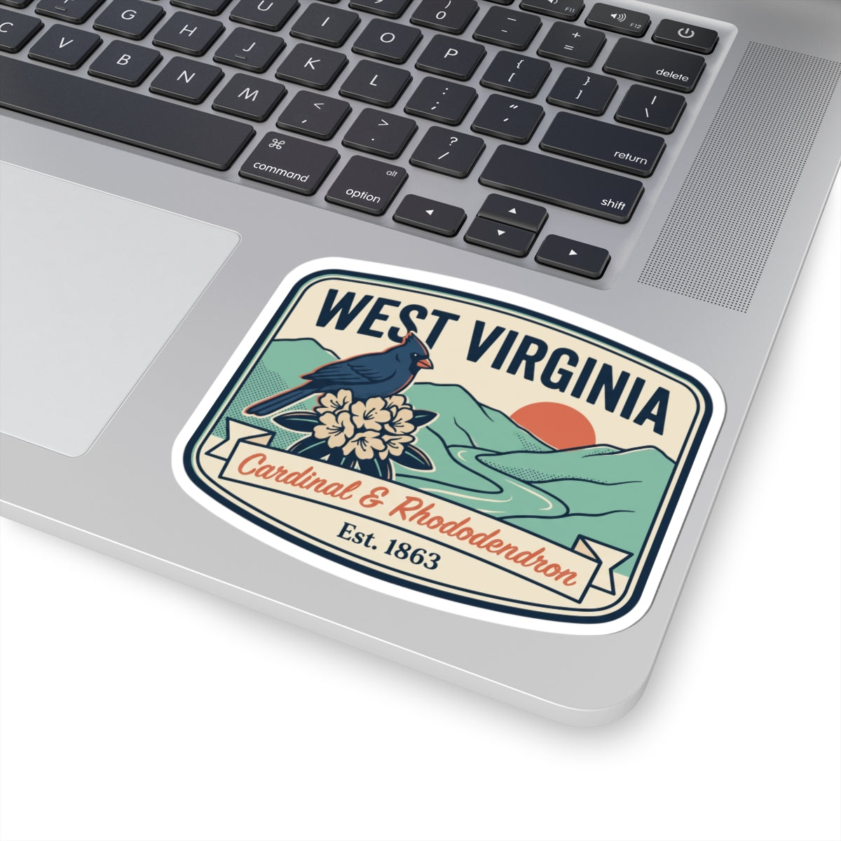 West Virginia badge decal on laptop, cardinal and rhododendron, Est. 1863.