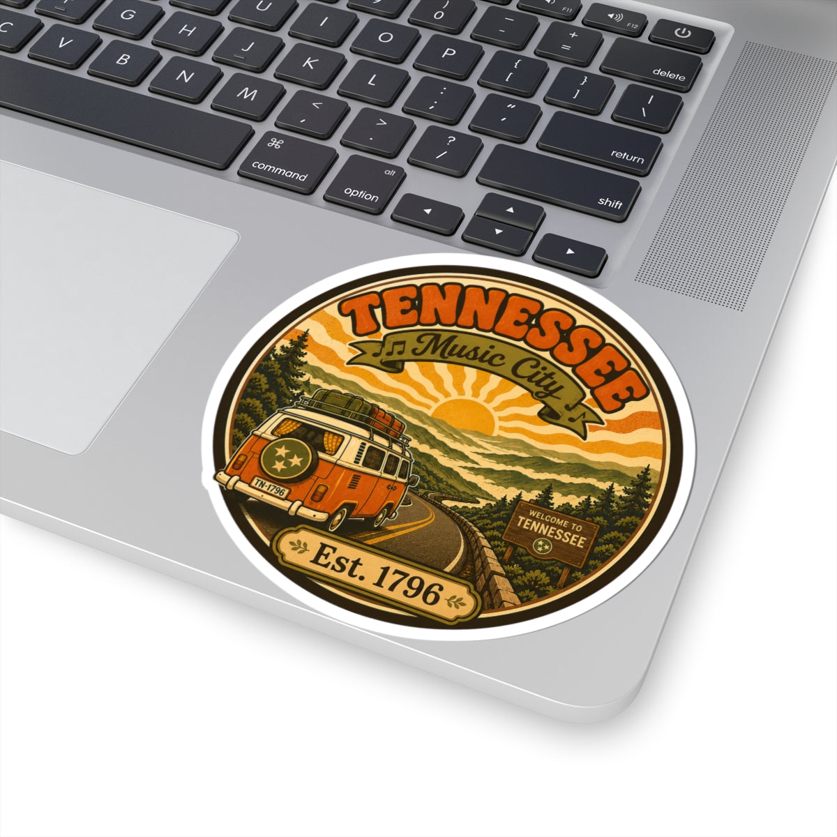Round Tennessee Music City sticker on laptop, vintage van landscape and Est. 1796 text
