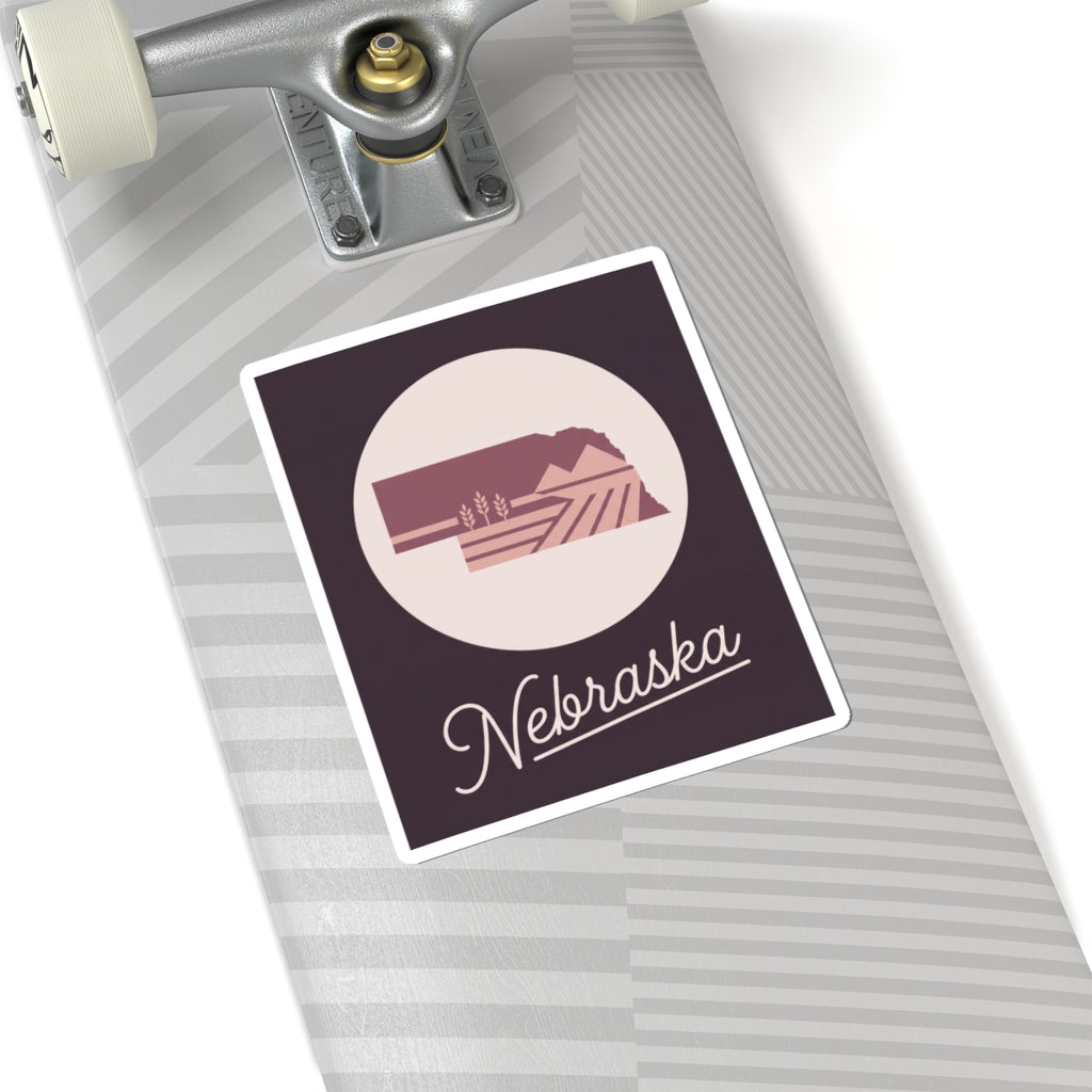 Square Nebraska decal on lined notebook, circular farmland icon with cursive “Nebraska”