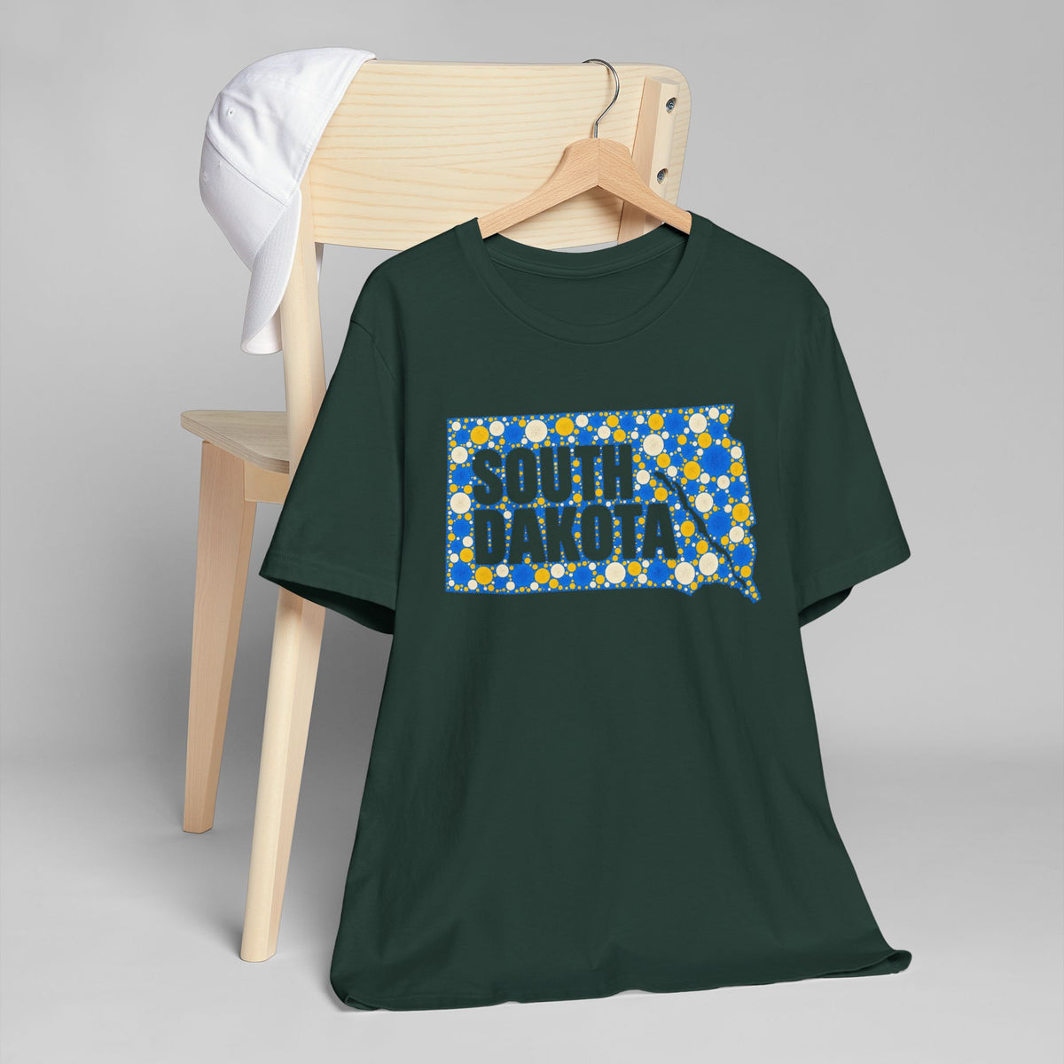 Dark green crewneck t-shirt with blue polka-dot South Dakota graphic on chest.