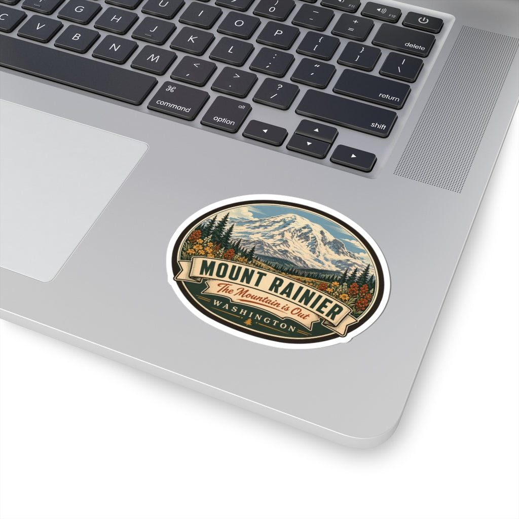 Oval Mount Rainier travel sticker on laptop lid with mountain artwork and WASHINGTON text