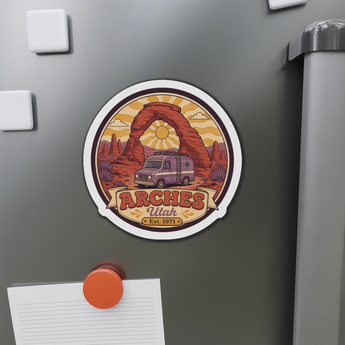 Die-cut round fridge magnet featuring red rock arches and a pink camper van illustration