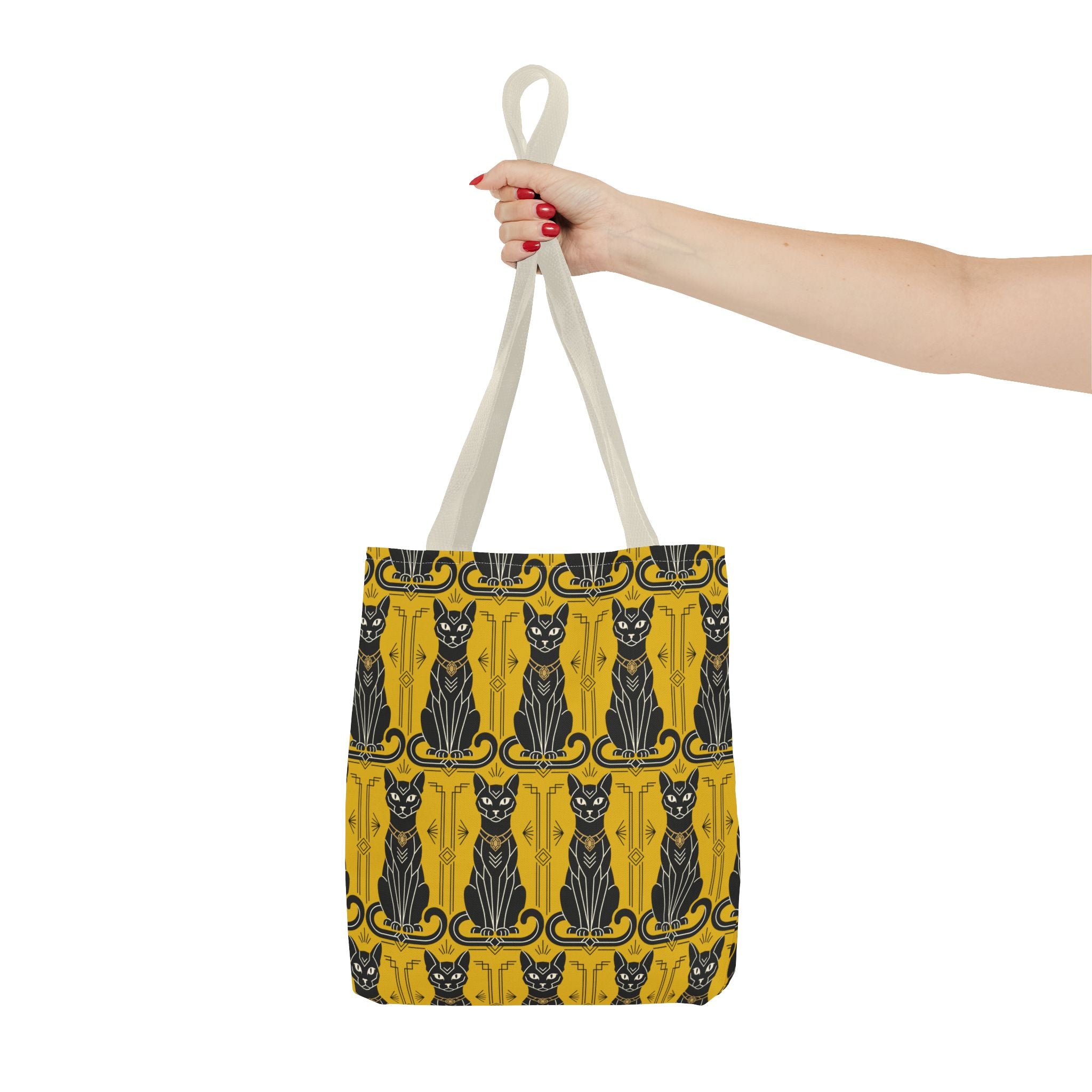 Yellow cat-pattern tote bag held by light beige handles, navy cats on striped background