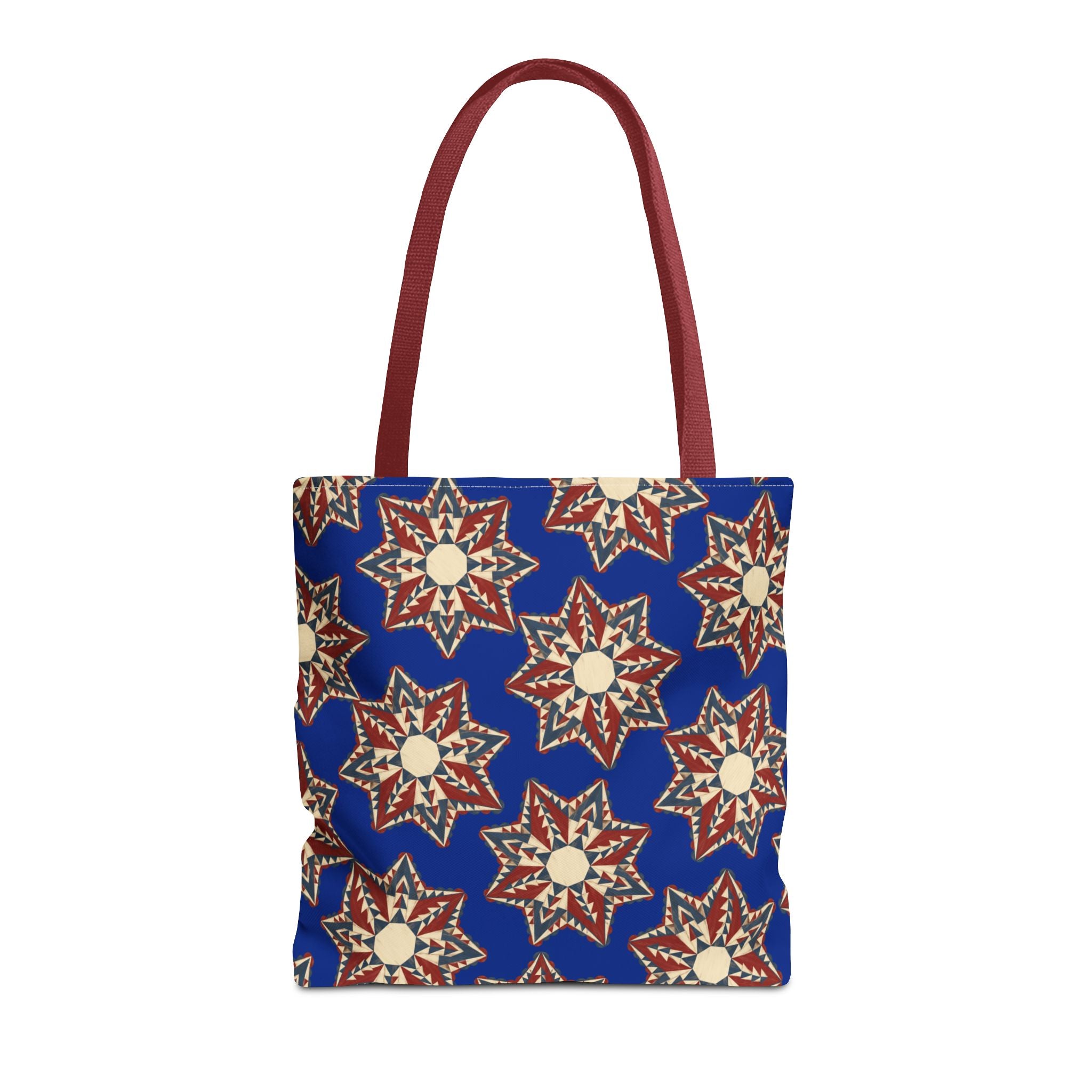 Blue tote bag with starburst floral pattern and dark red handles
