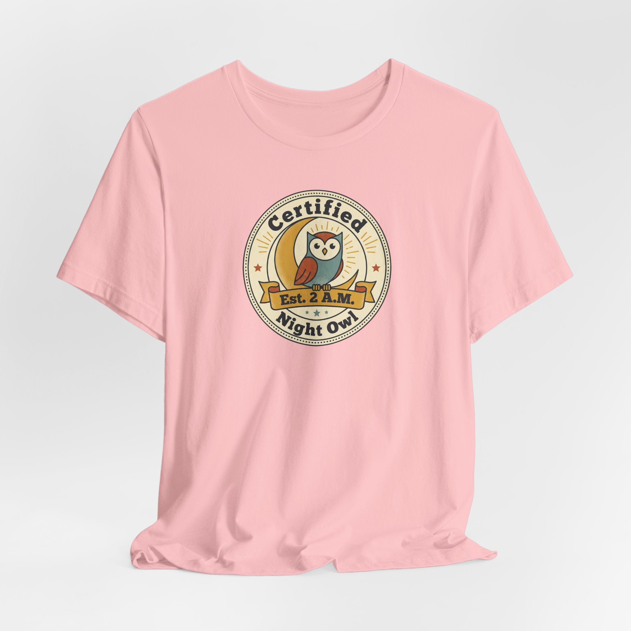 Pink T-shirt with round Certified Night Owl badge graphic on chest, short sleeves