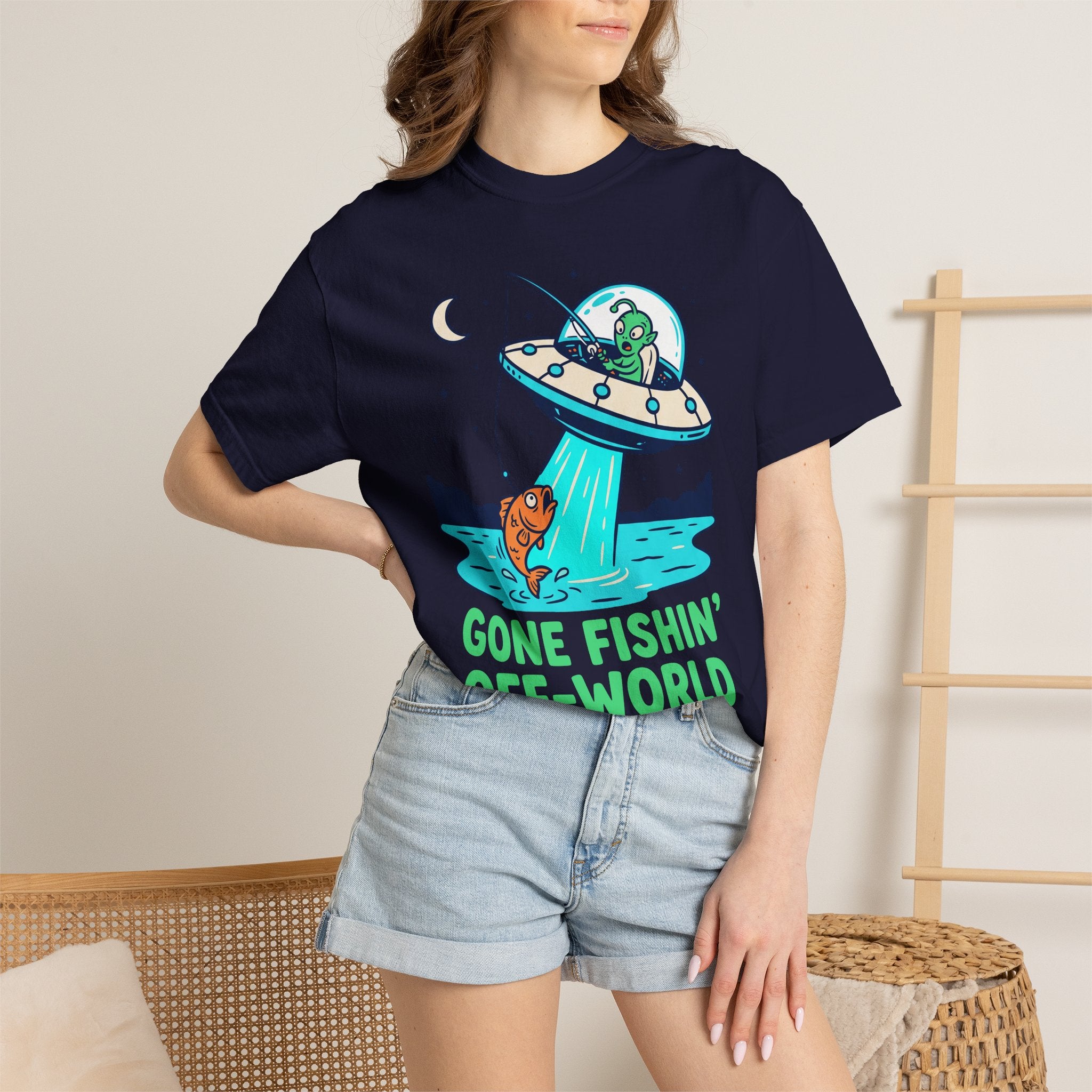 Navy T-shirt worn by model, alien fishing UFO graphic with “GONE FISHIN’ OFF-WORLD”