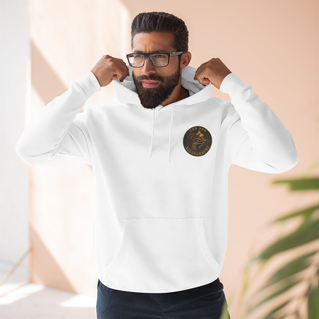 White pullover hoodie worn by model, front pocket and chest patch visible