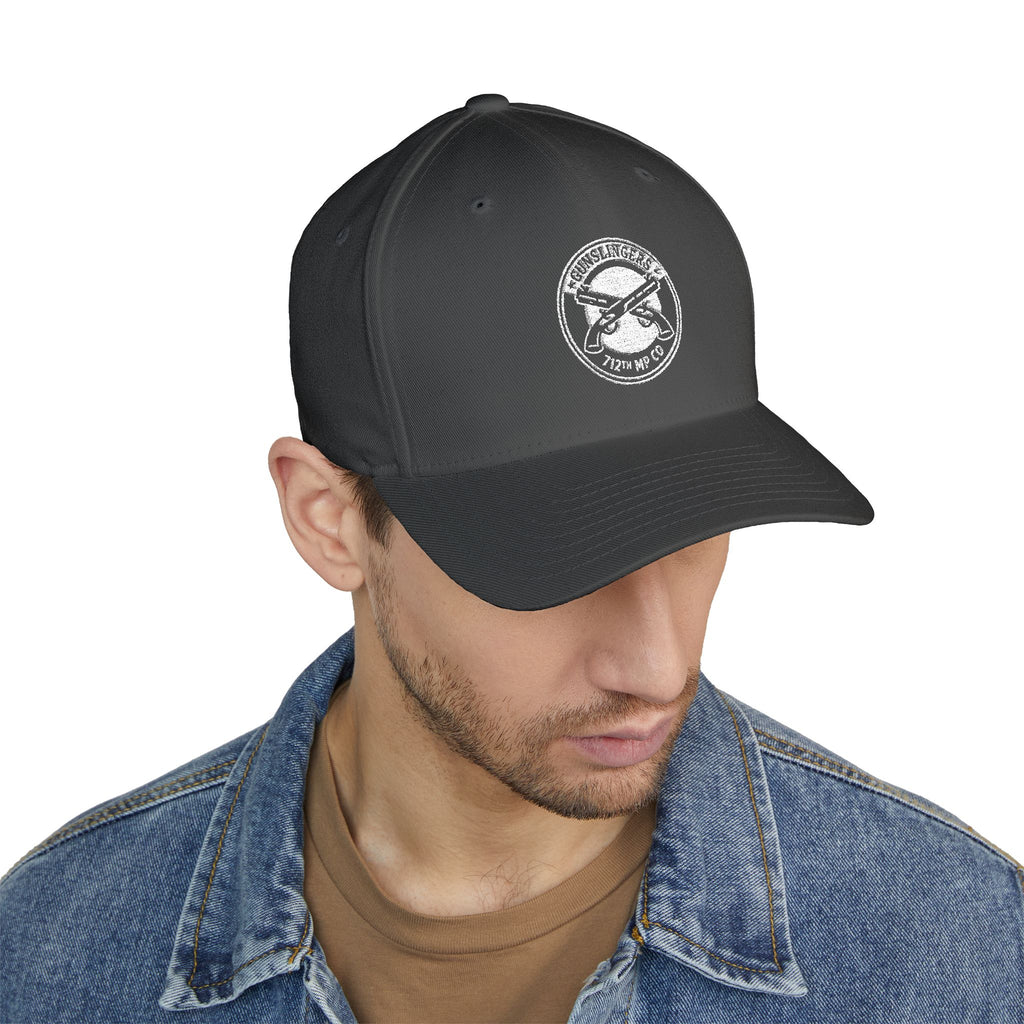Embroidered baseball cap in dark grey with white circular emblem on front panel.