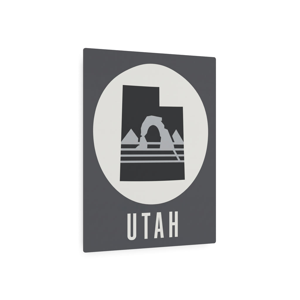 Utah metal wall art sign, dark square with white oval circle, mountain arch graphic and UTAH text