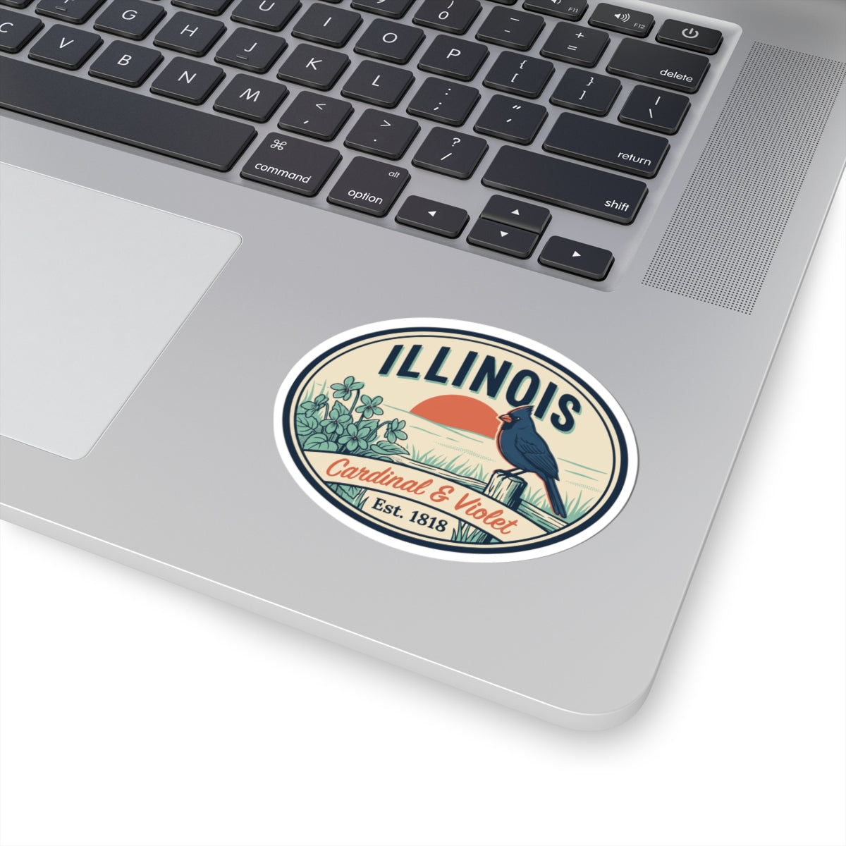 Oval vinyl sticker decal on laptop showing Illinois cardinal and violet badge