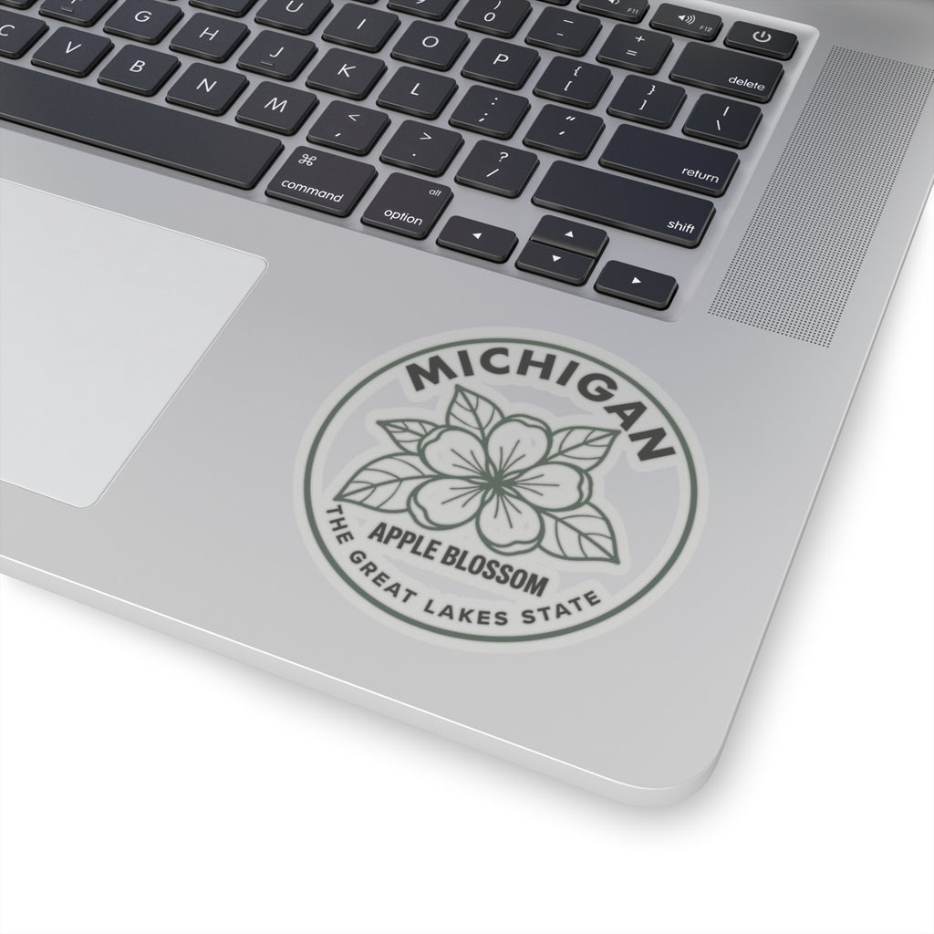 Transparent vinyl apple blossom sticker on laptop, circular Michigan logo seal with outline flower