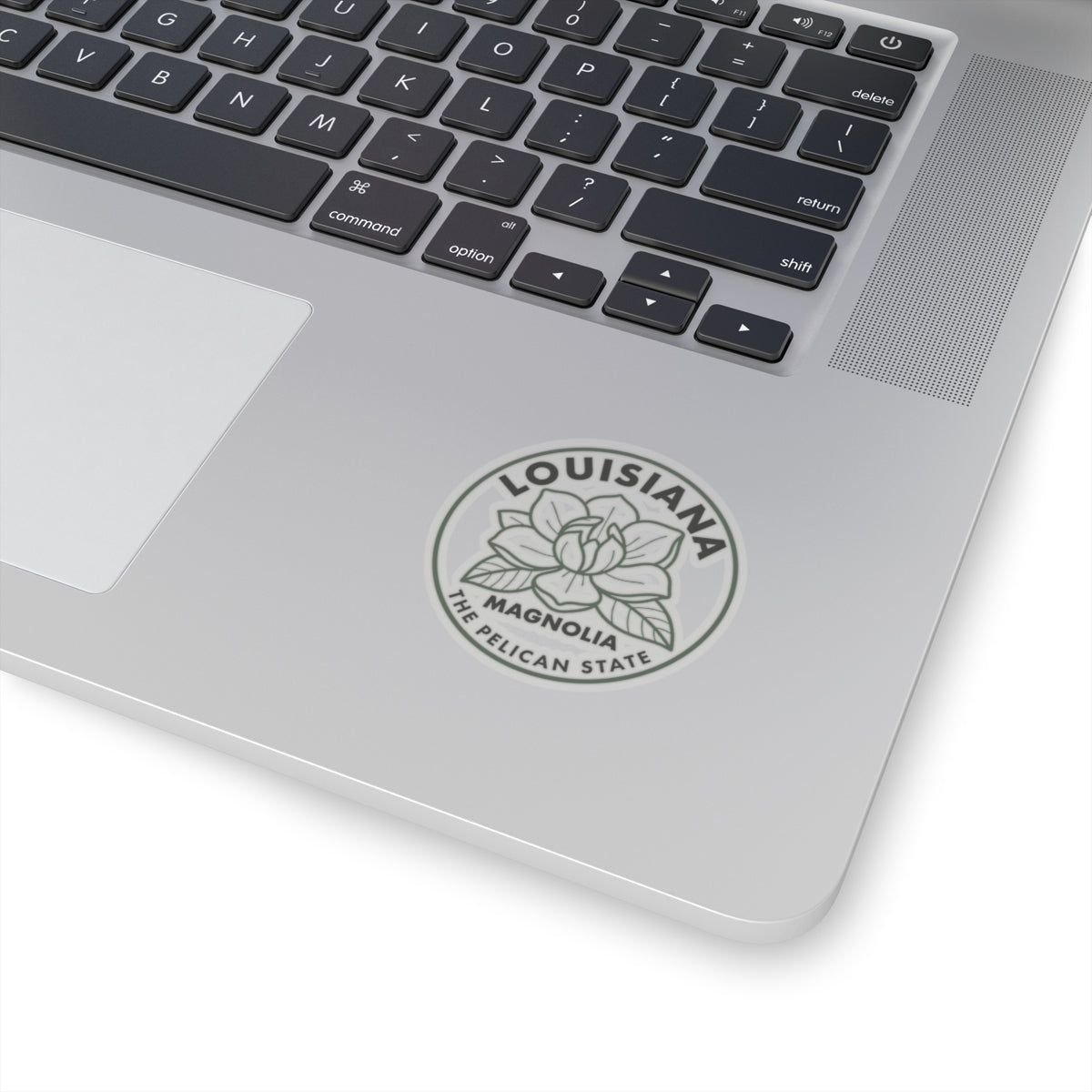 Transparent vinyl round Louisiana magnolia sticker on laptop lid, gray flower and text ring