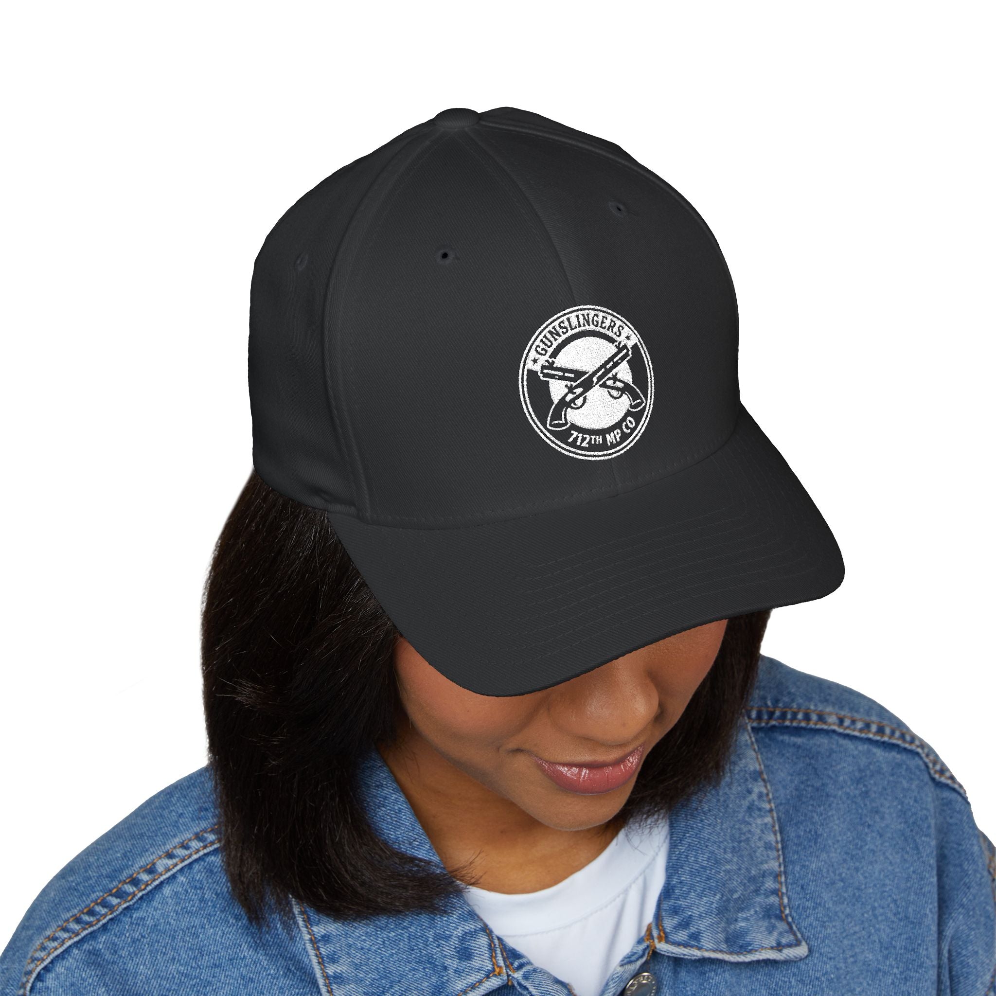Black baseball cap with white circular embroidered badge on front