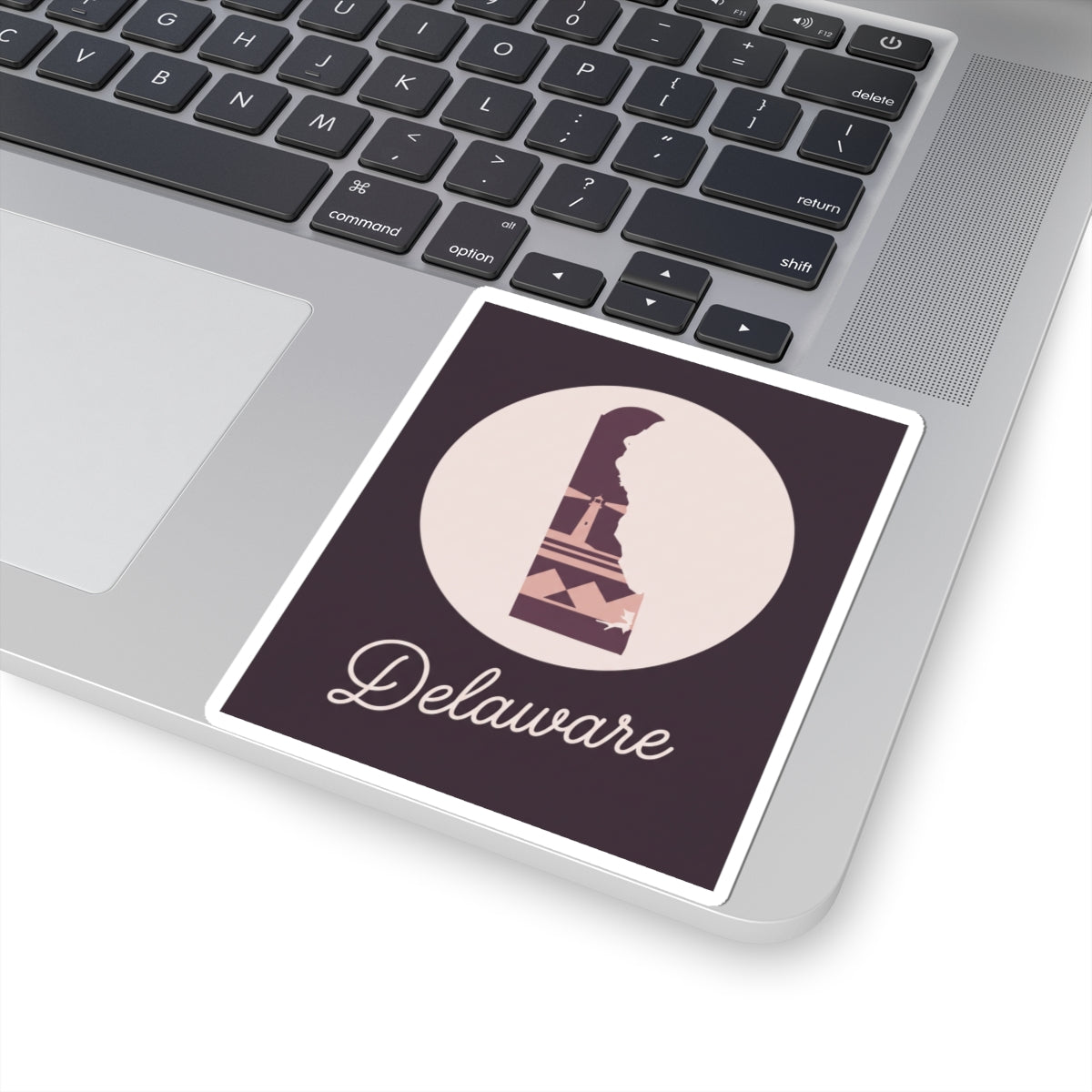 Delaware silhouette vinyl sticker on laptop, mauve lighthouse graphic with 'Delaware' script
