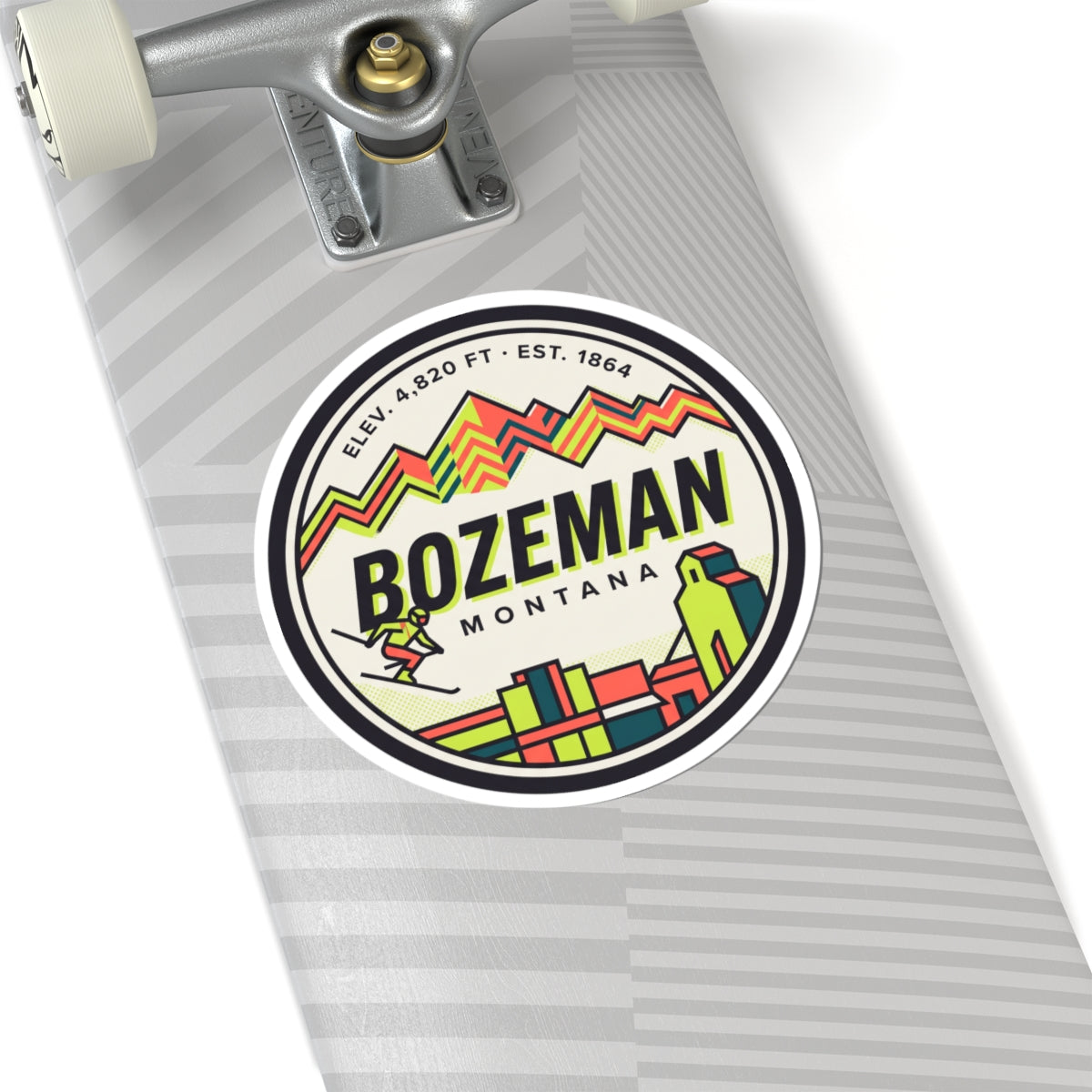 Round Bozeman Montana sticker on a skateboard deck, with colorful mountain and town art