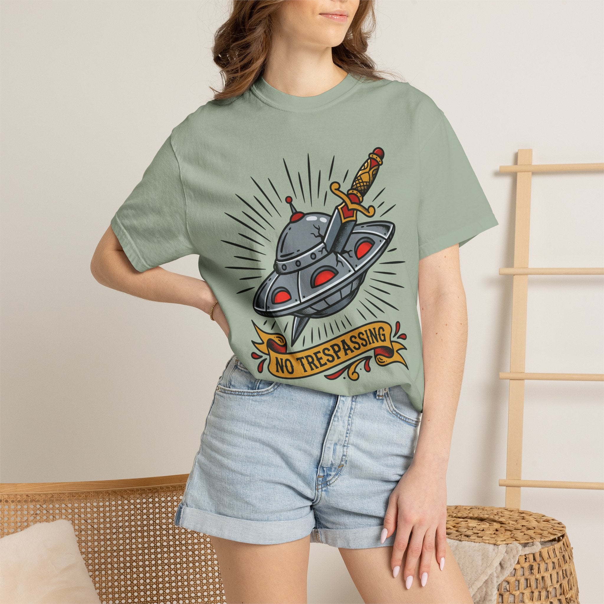 Sage green T-shirt with UFO and dagger graphic and “No Trespassing” text
