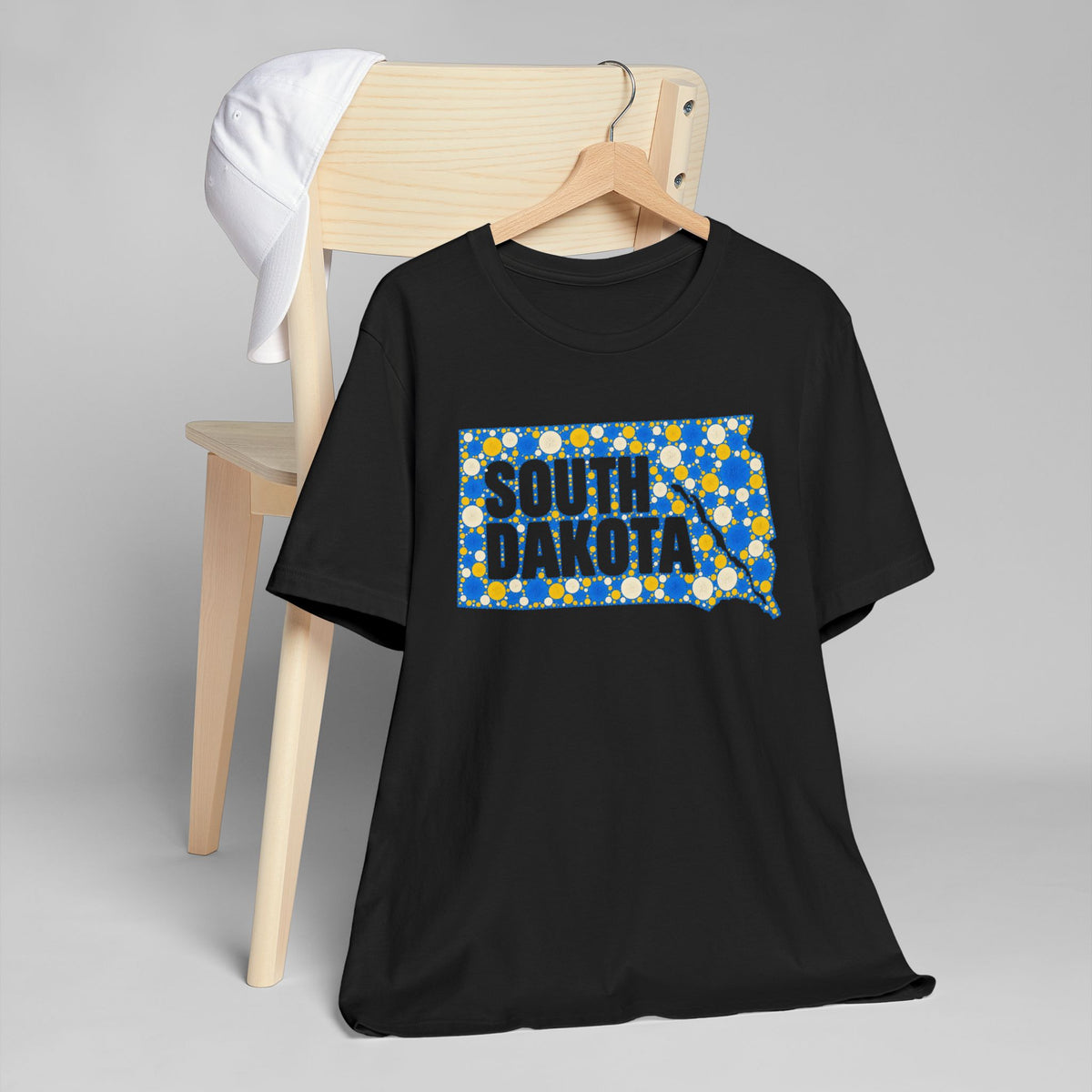 Black t-shirt with polka dot South Dakota map graphic in blue and yellow
