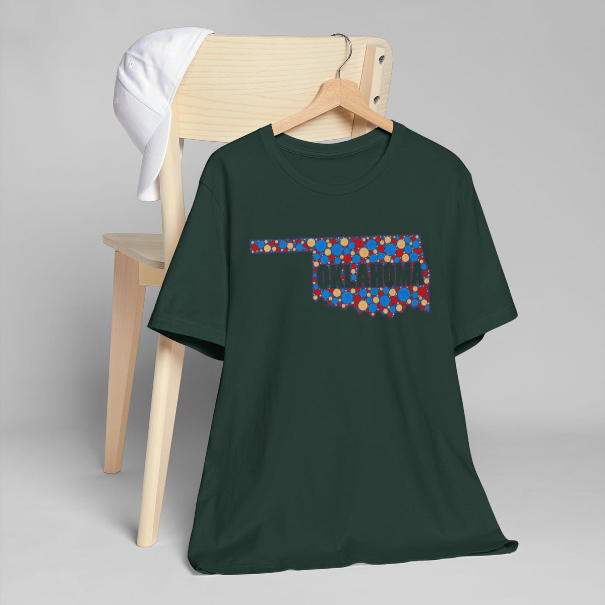 Forest green T-shirt with colorful Oklahoma outline floral graphic across chest