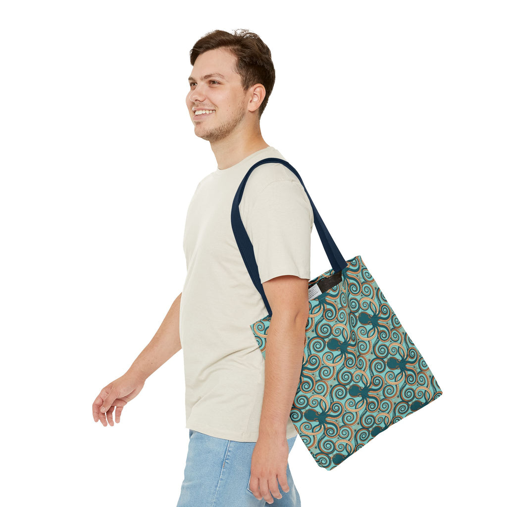 Teal octopus swirl tote bag with navy shoulder straps, all-over ocean print.