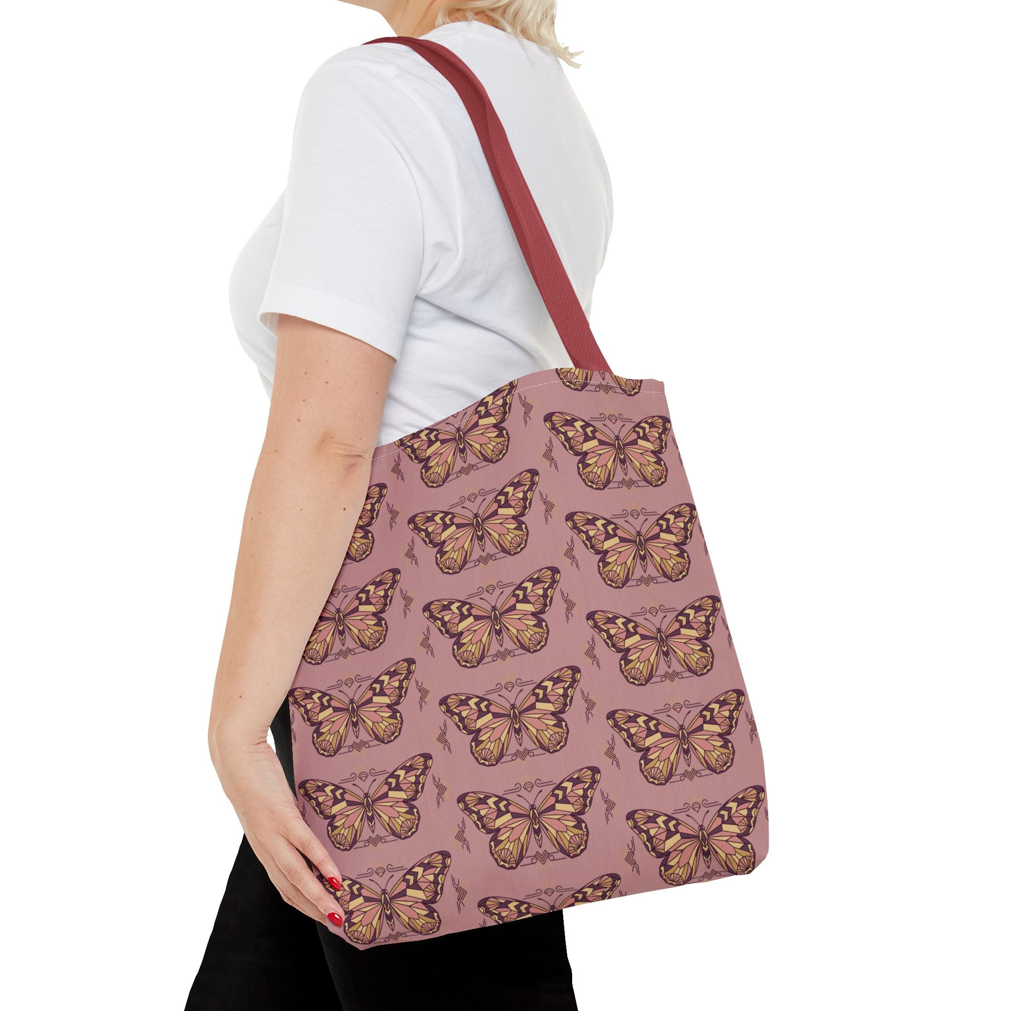 Butterfly-print tote bag in pink with brown-red straps, side view on person