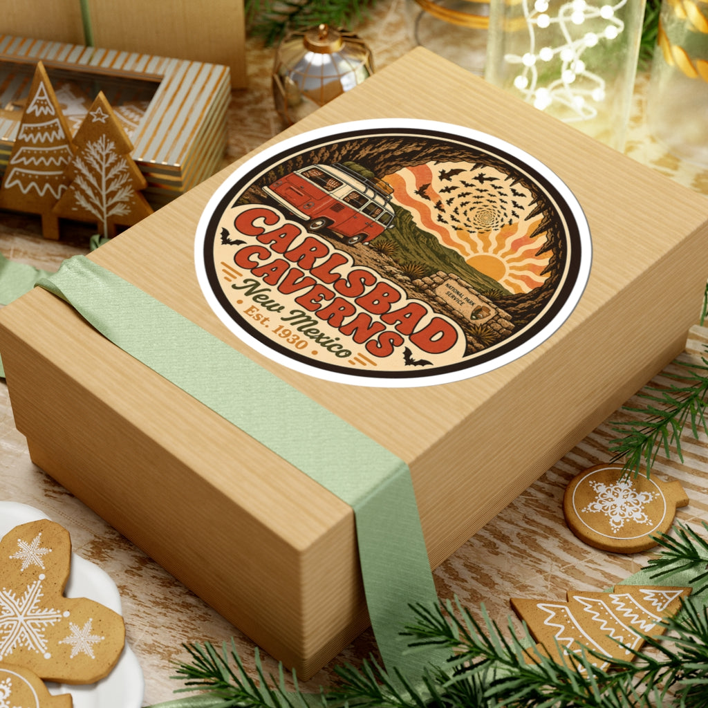 Round Carlsbad Caverns sticker on top of a wrapped gift box, orange camper van in cave scene
