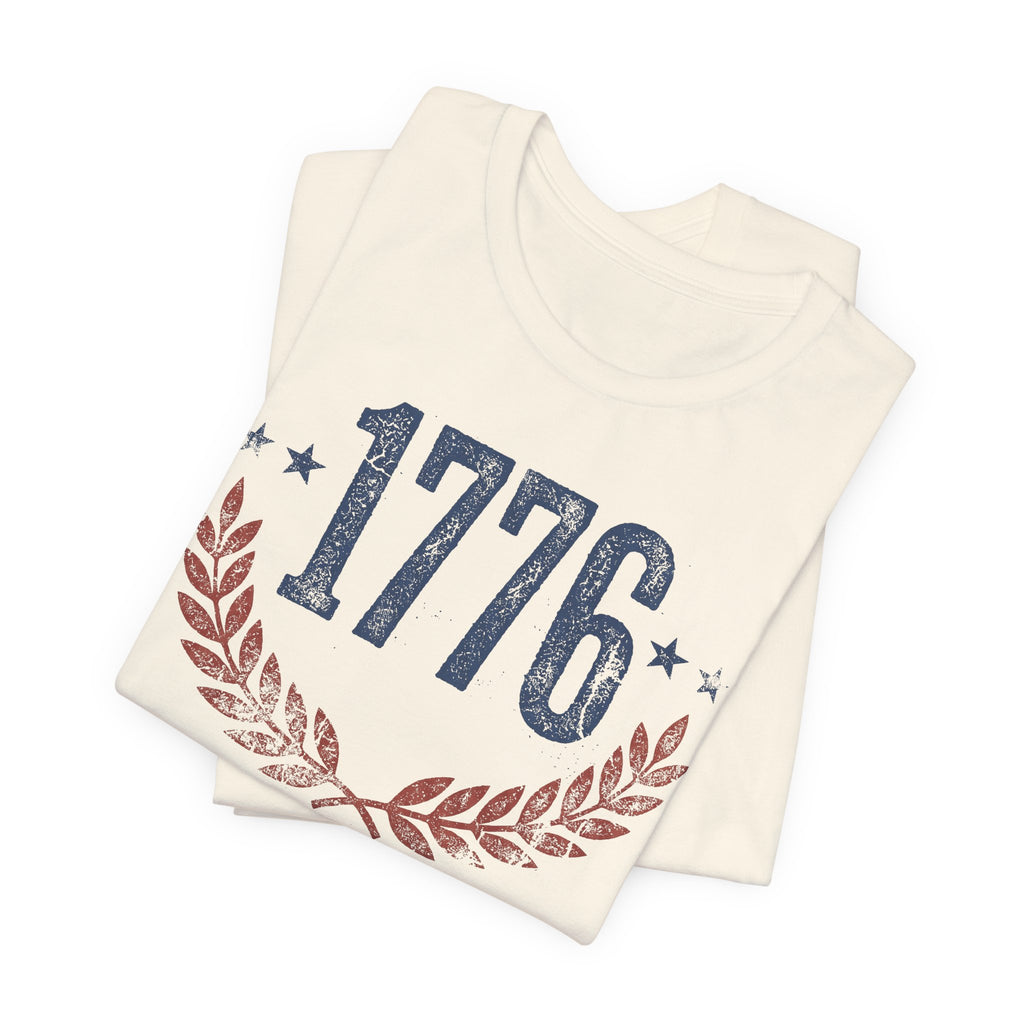 Cream T-shirt with “1776” graphic, stars, and laurel wreath