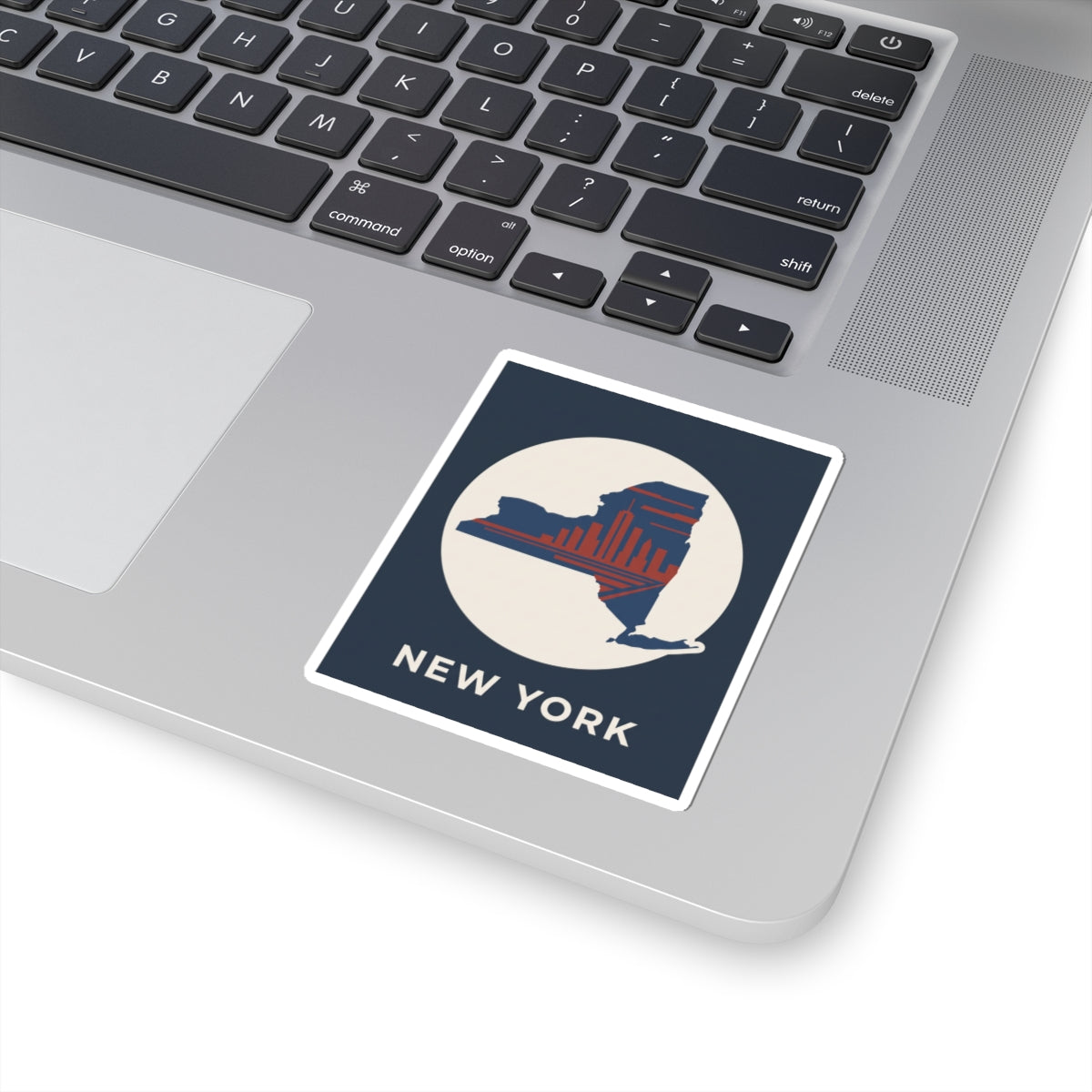 New York skyline sticker on laptop: blue border with state silhouette, red skyline, “NEW YORK”