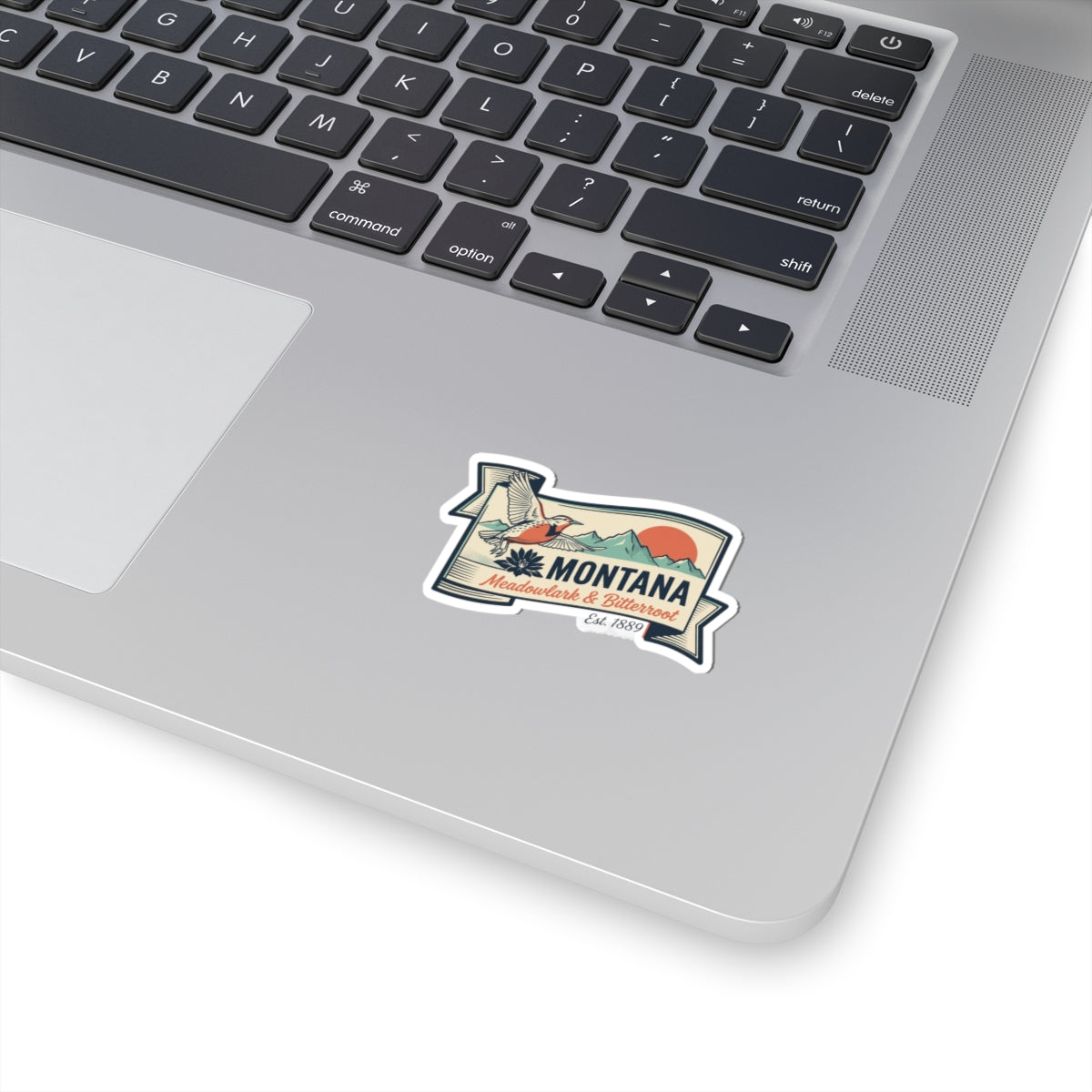 White kiss-cut vinyl state badge sticker with Montana retro emblem on laptop lid