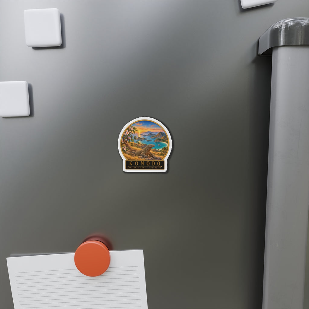 Komodo die-cut magnet attached to a stainless fridge, showing dragon scene and "KOMODO"